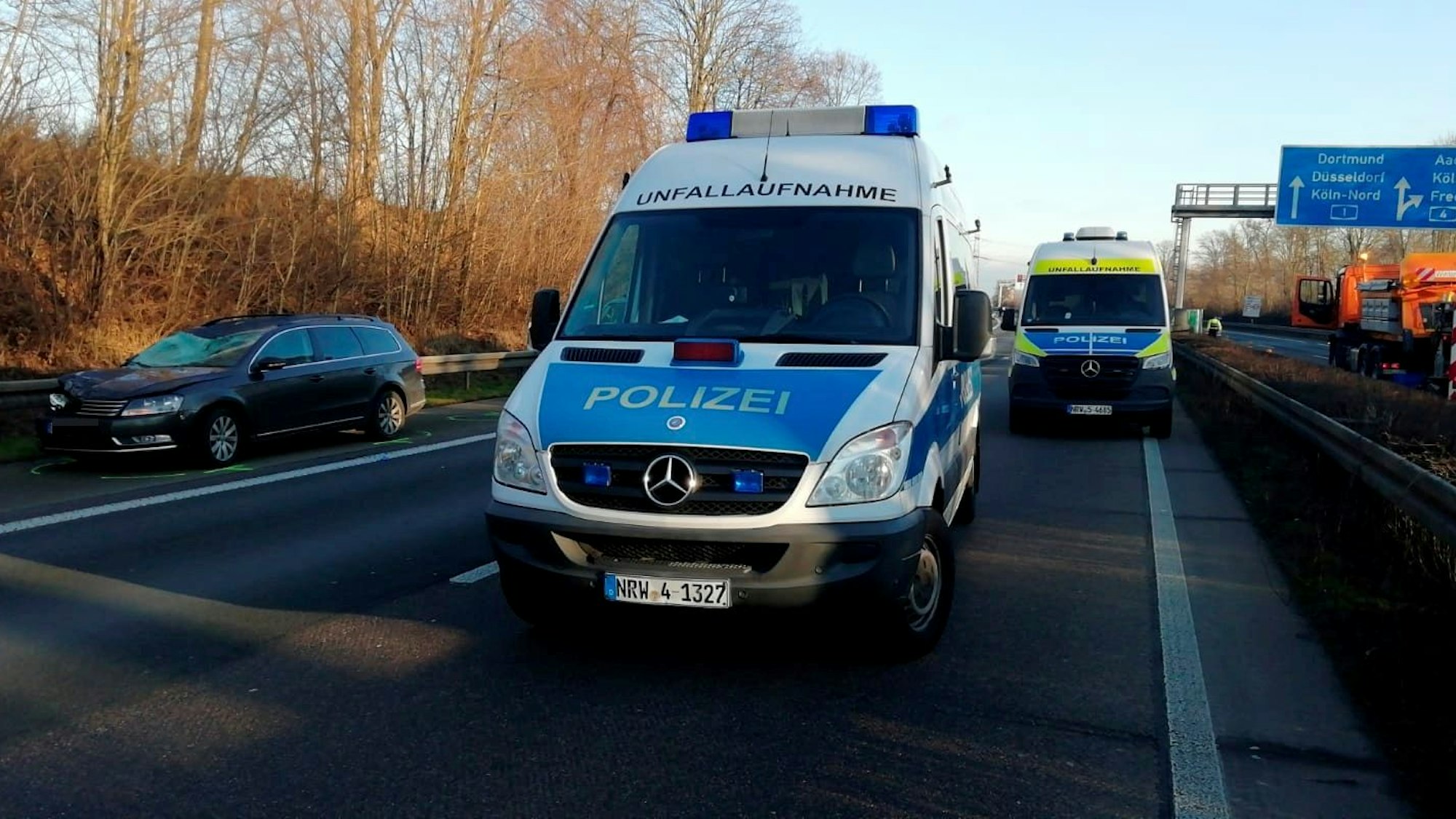 Zwei Polizeifahrzeuge des Unfallaufnahmeteams stehen auf der Autobahn.