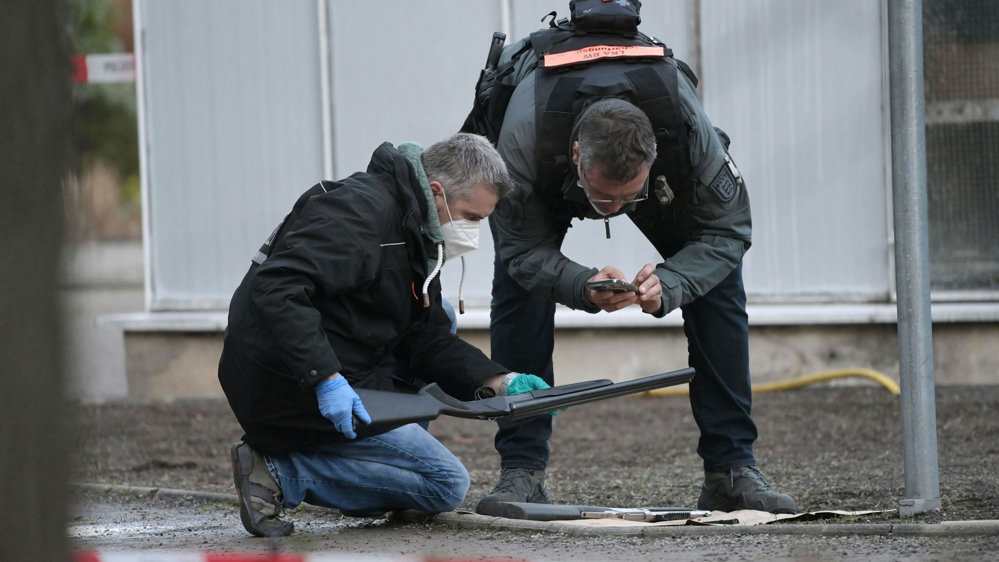 Polizeibeamte untersuchen eine Waffe am Gelände der Heidelberger Universität.