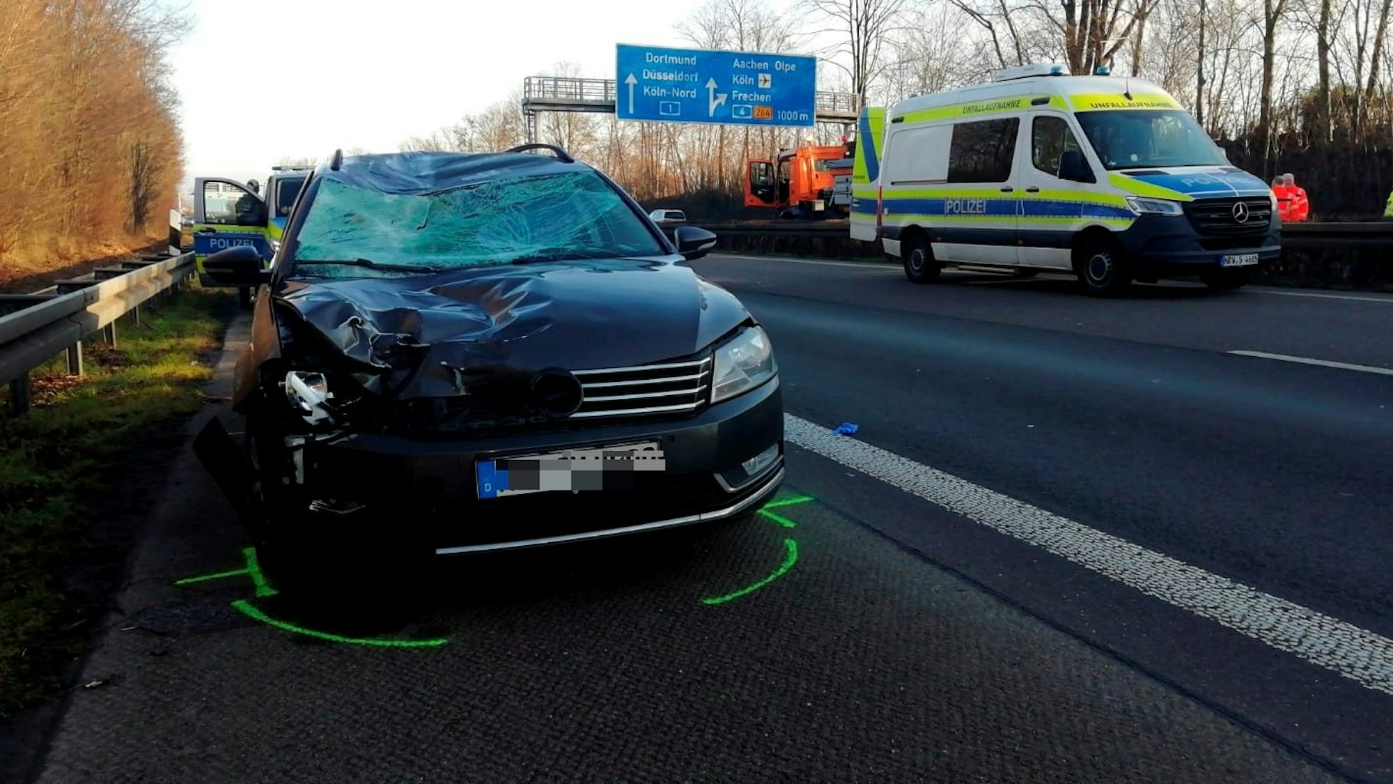 Ein VW Passat steht auf dem Seitenstreifen der Autobahn, seine Frontscheibe sowie die Motorhaube sind stark beschädigt.