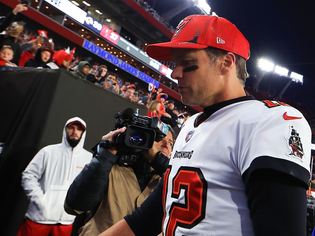 Tom Brady geht vom Feld, trägt eine rote Kappe.