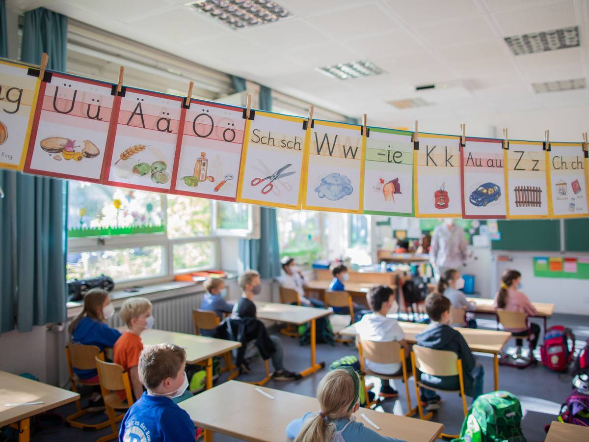 Schülerinnen und Schüler hören im Klassenzimmer ihrer Lehrerin zu. Foto von der dpa