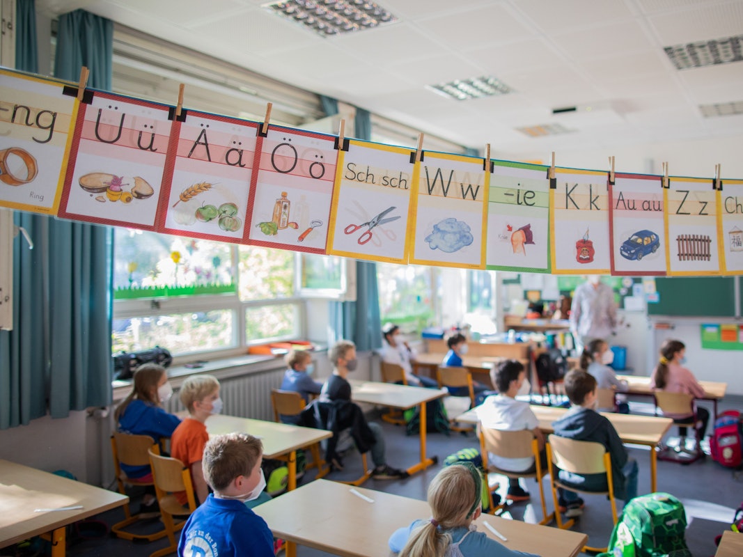 Schülerinnen und Schüler hören im Klassenzimmer ihrer Lehrerin zu. Foto von der dpa