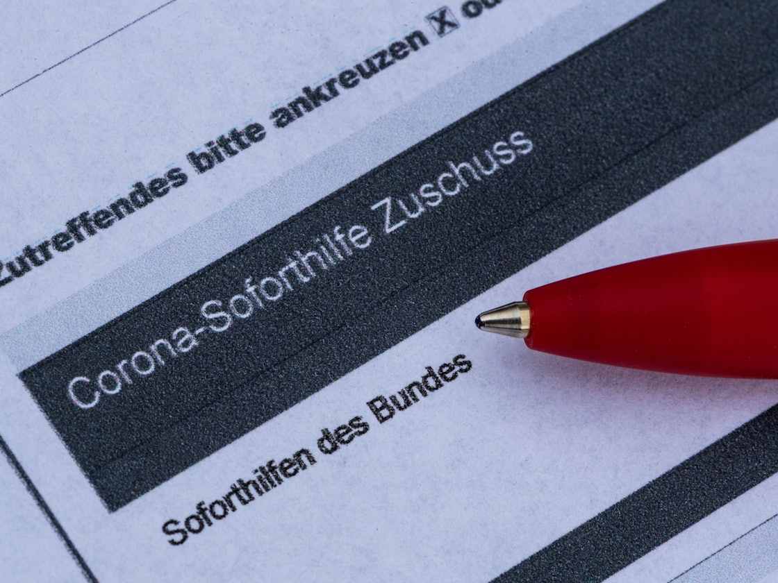 Ein Stift liegt auf einem Antrag für den Corona-Soforthilfe-Zuschuss.