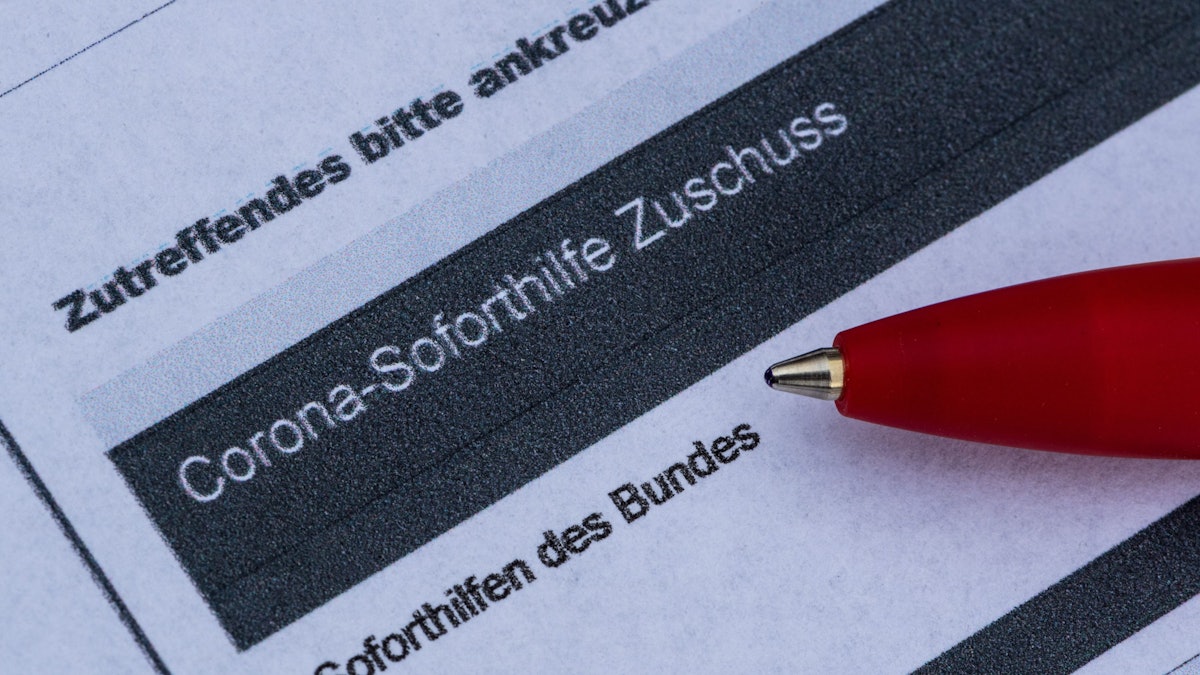 Ein Stift liegt auf einem Antrag für den Corona-Soforthilfe-Zuschuss.