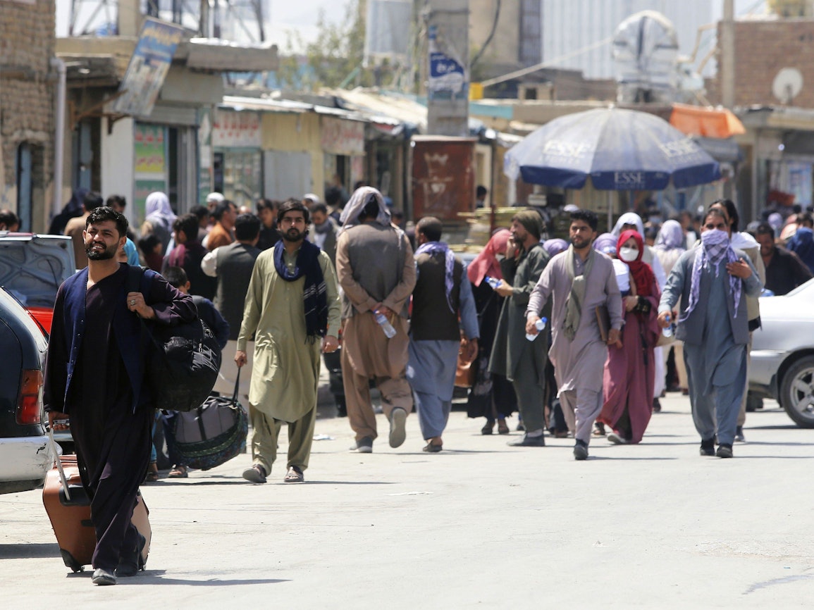 Menschen begeben sich zu einer Militäreinrichtung auf einem Flughafen in Kabul. Foto vom 23. August 2021.