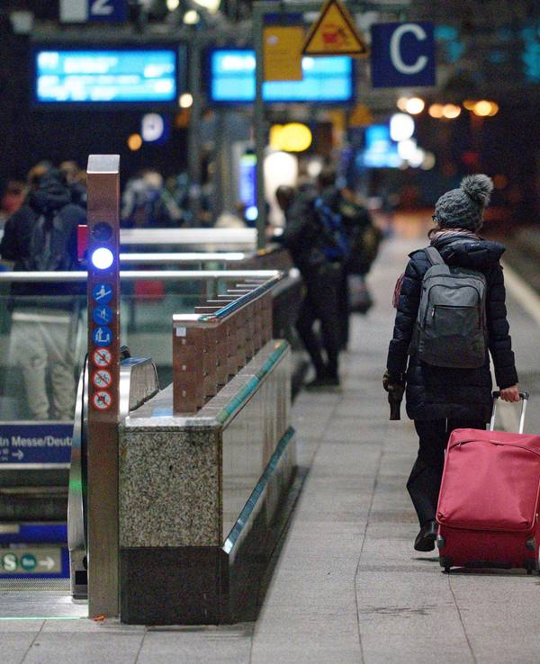 Eine Frau geht am Hauptbahnhof in Köln mit Koffer zu ihrem Zug. Foto von der dpa