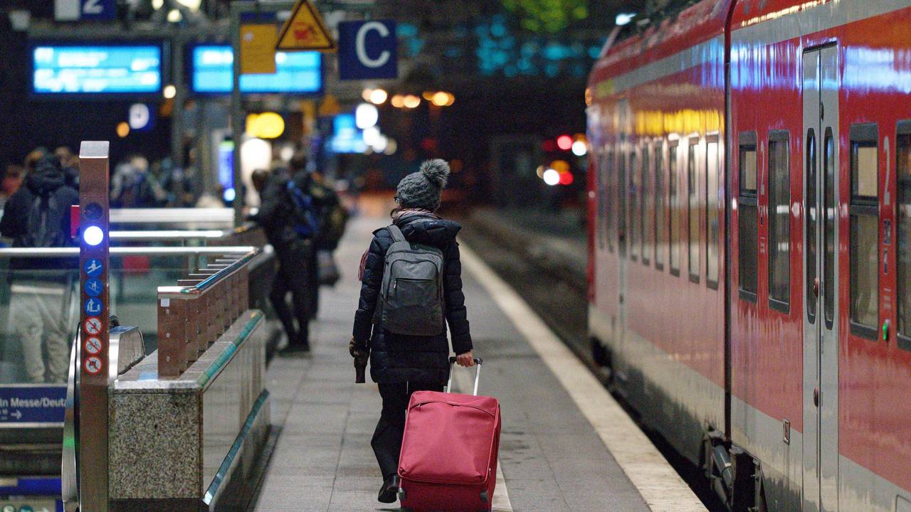 Eine Frau geht am Hauptbahnhof in Köln mit Koffer zu ihrem Zug. Foto von der dpa