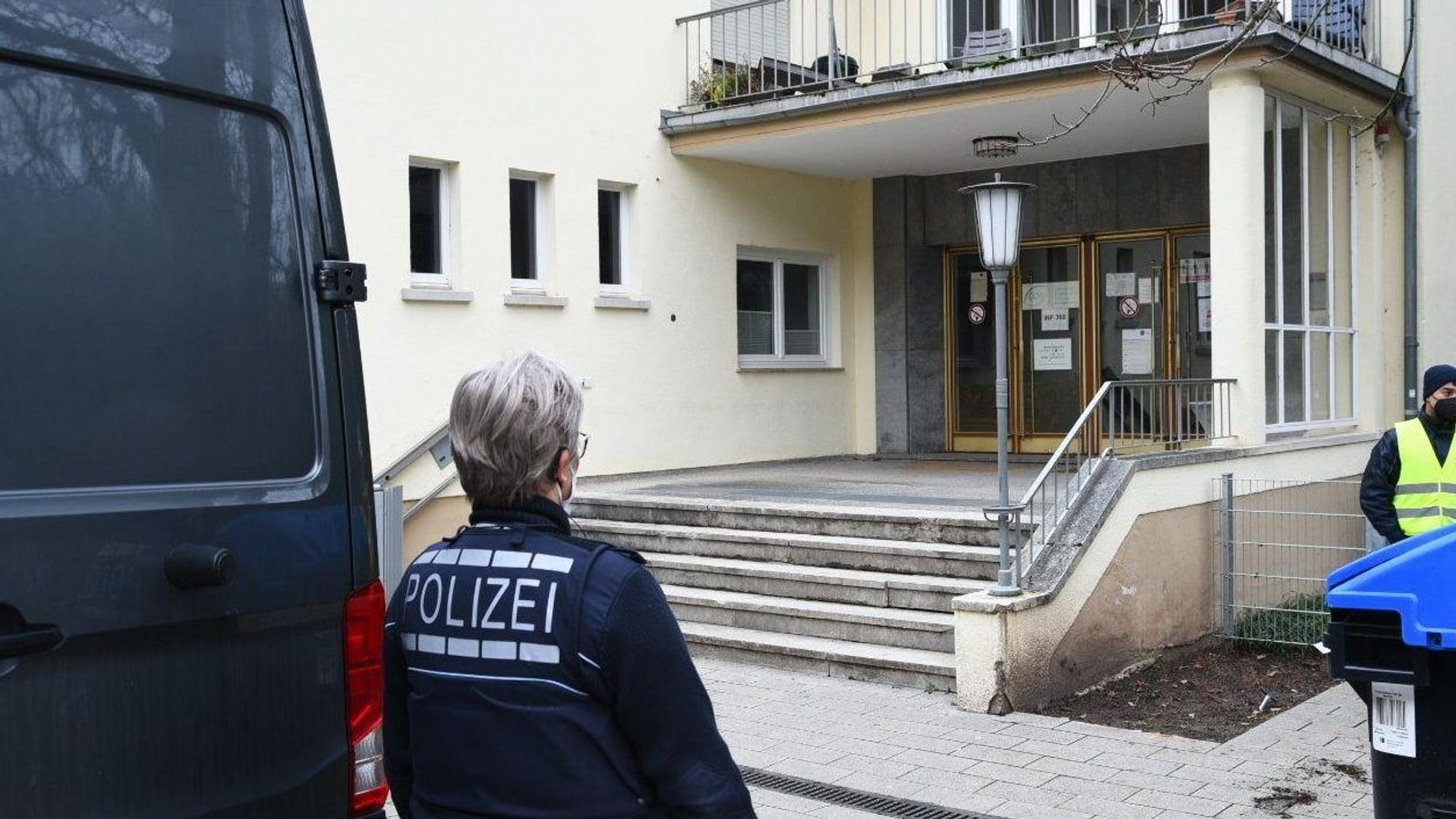 Polizei und Wachschutz stehen am 25. Januar 2022 an dem Eingang zum Gebäude auf dem Gelände der Heidelberger Universität in dem sich der Tatort eines Amoklaufes befindet.