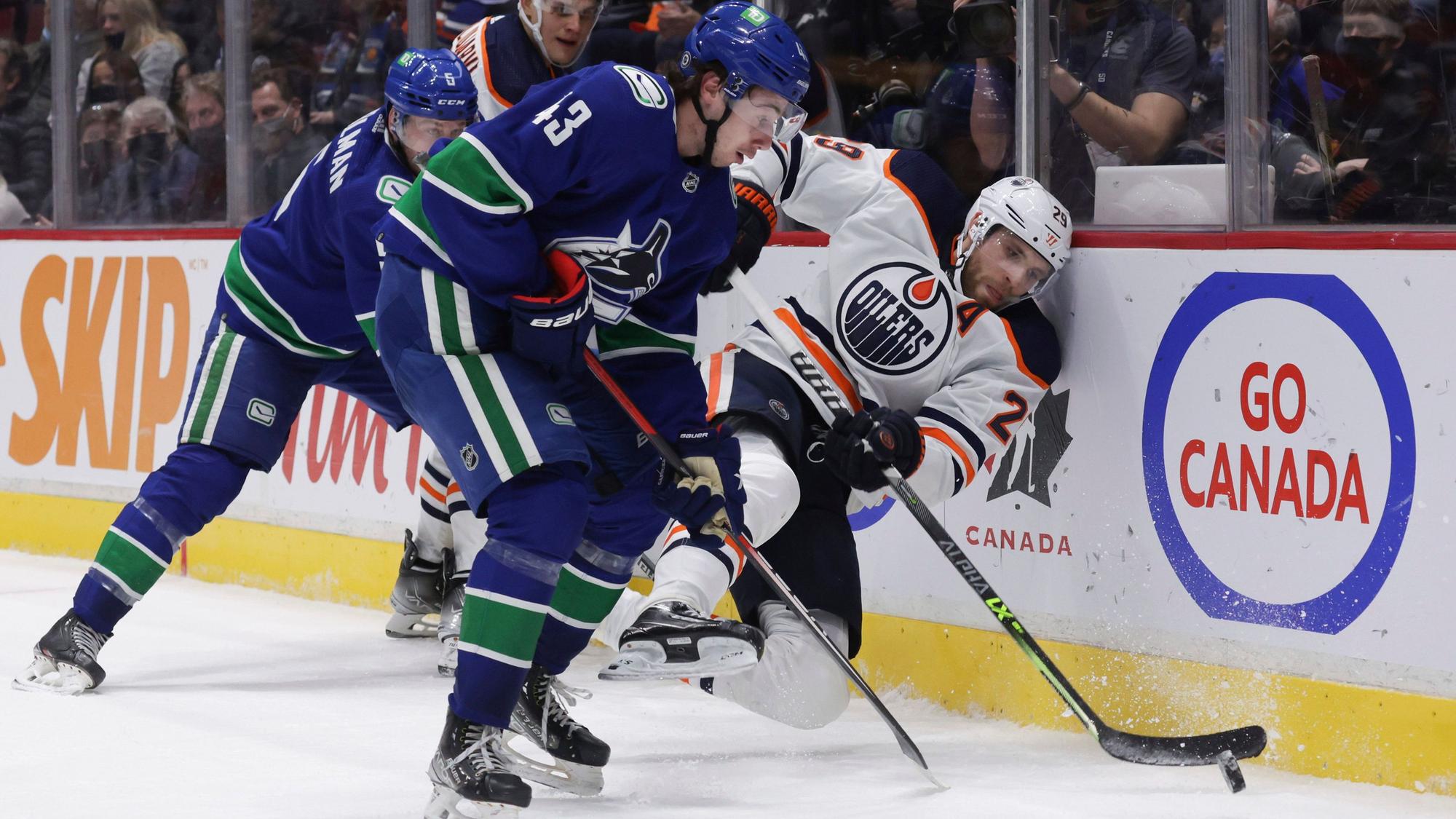 Leon Draisaitl wird im Zweikampf Richtung Bande gedrückt.