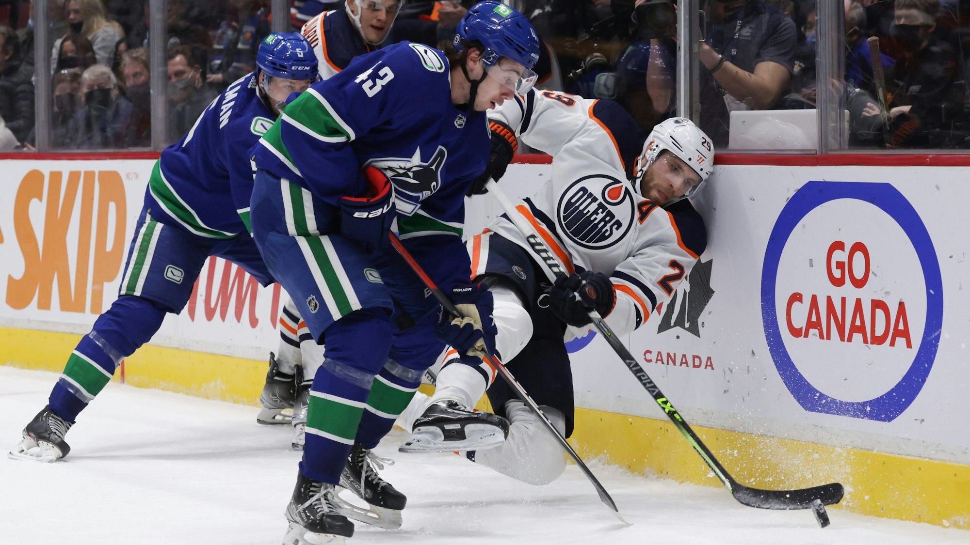 Leon Draisaitl wird im Zweikampf Richtung Bande gedrückt.