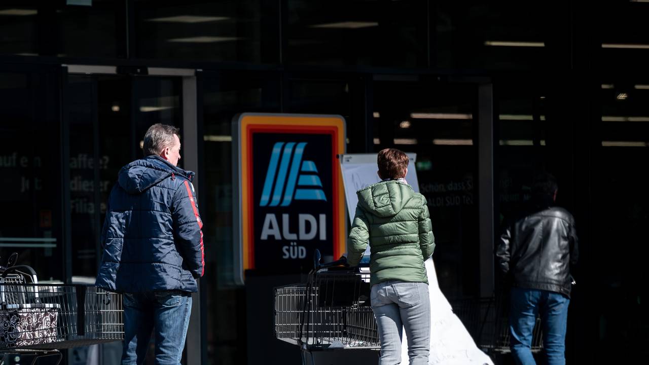 Menschen warten mit Abstand zueinander vor einer Filiale von Aldi Süd in Mülheim auf Einlass. Das Bild entstand am 23. März 2020.