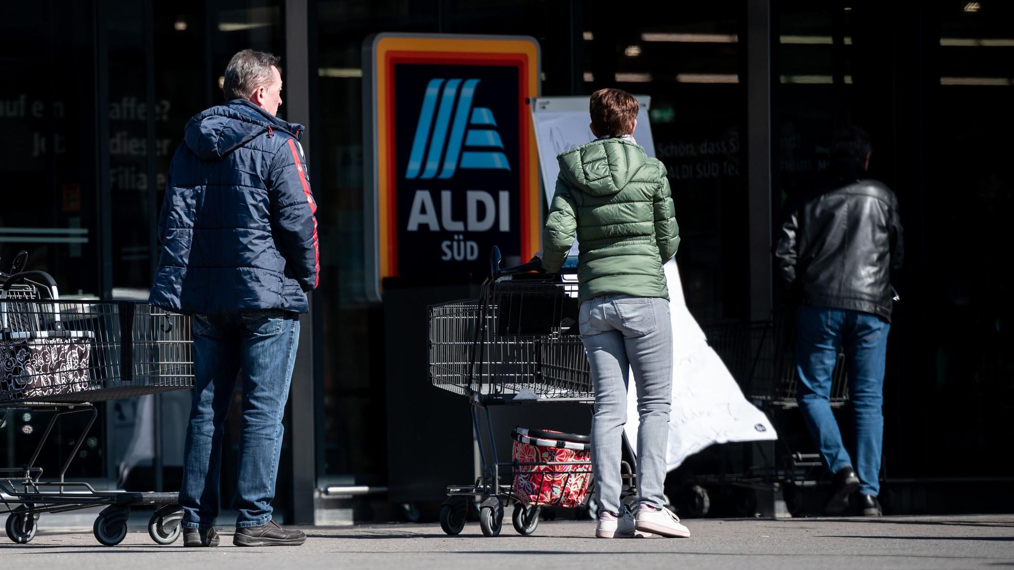 Menschen warten mit Abstand zueinander vor einer Filiale von Aldi Süd in Mülheim auf Einlass. Das Bild entstand am 23. März 2020.