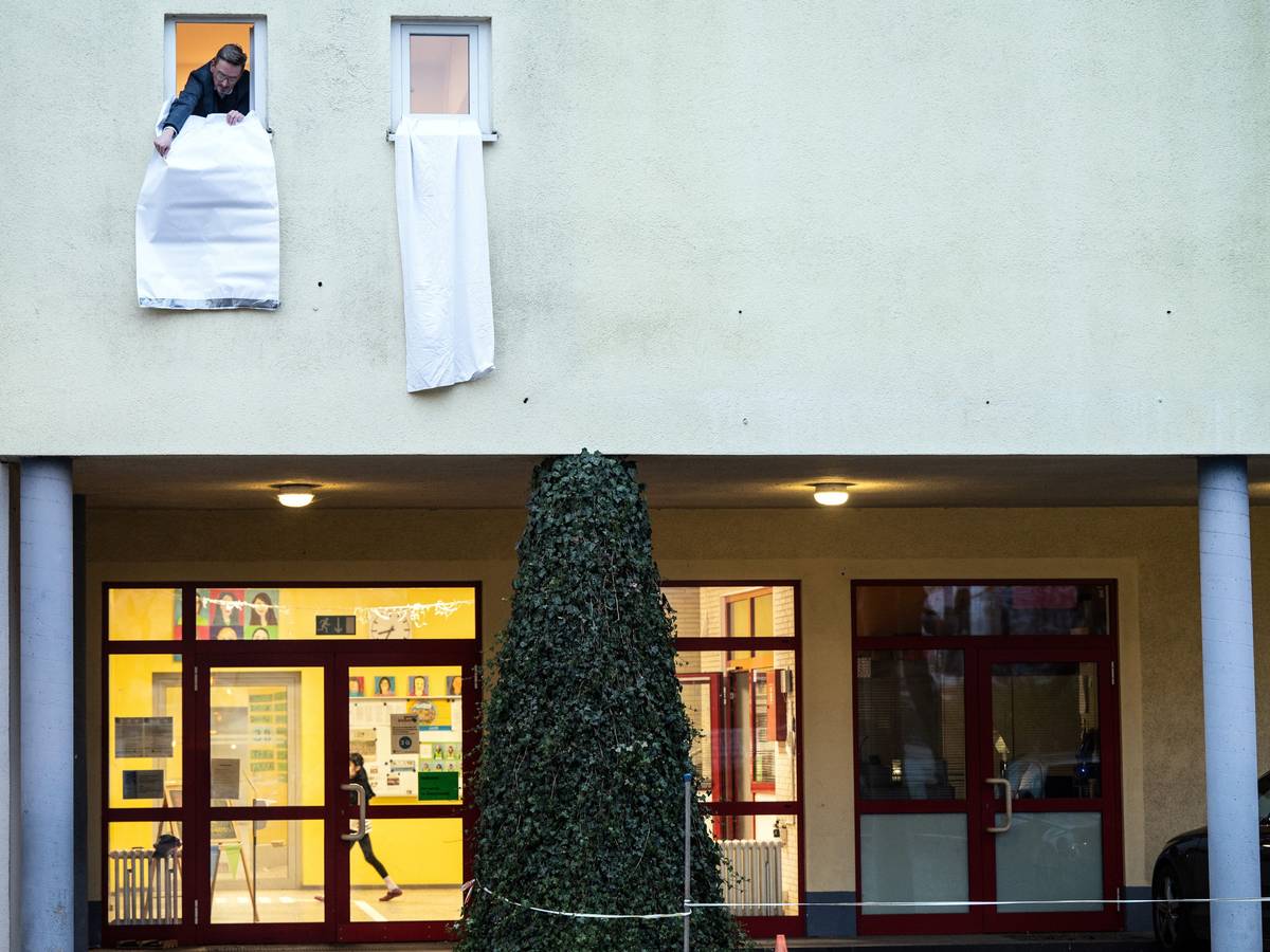 Ein Mann hängt eine weiße Fahne aus einem Fenster.