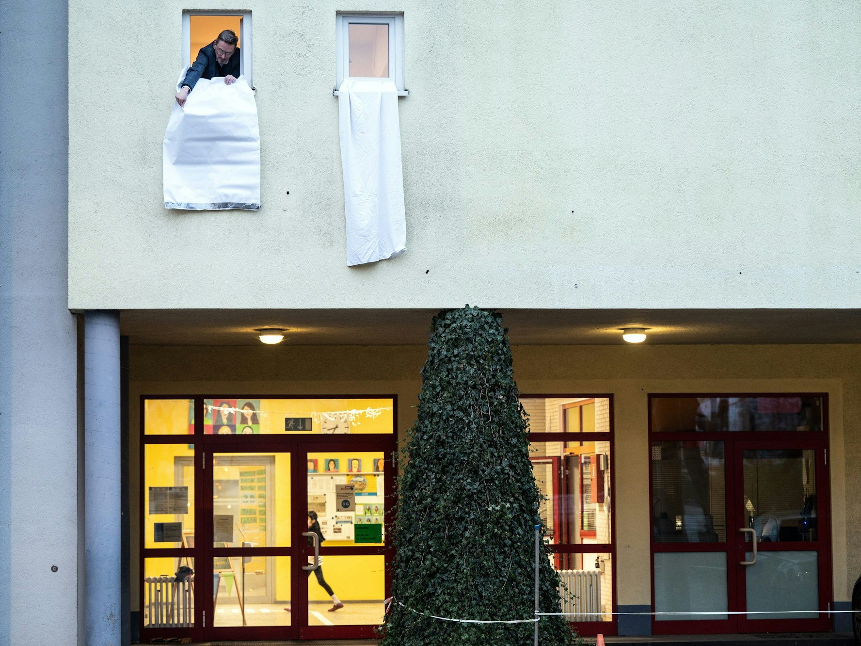 Ein Mann hängt eine weiße Fahne aus einem Fenster.