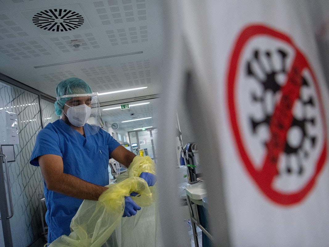 Ein Pfleger zieht beim Verlassen der Intensivstation für Corona-Patienten am Sana Klinikum Offenbach seinen Schutzkittel aus.
