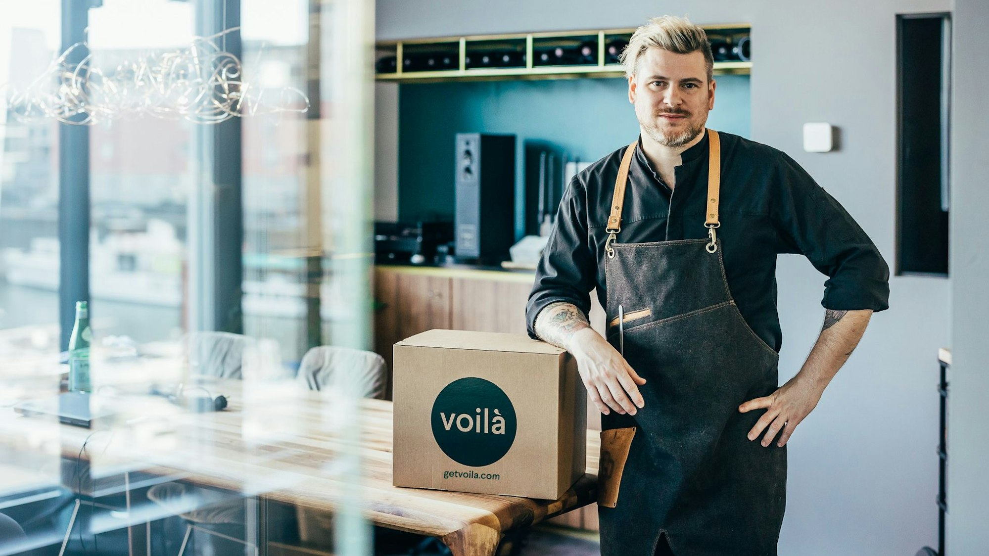 Daniel Gottschlich steht mit einem Pappkarton in seinem Lokal.