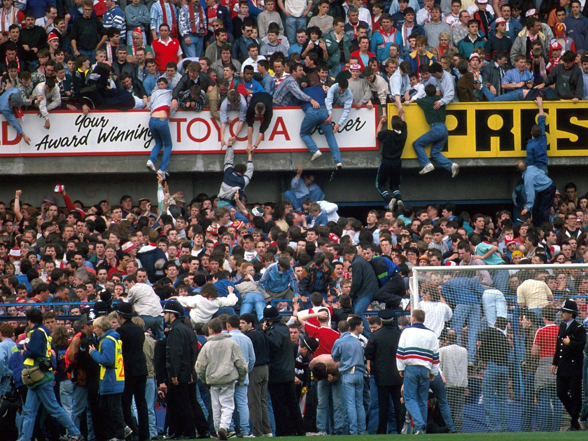 Fans klettern aus dem Unterrang des Stadions in den Oberrand.