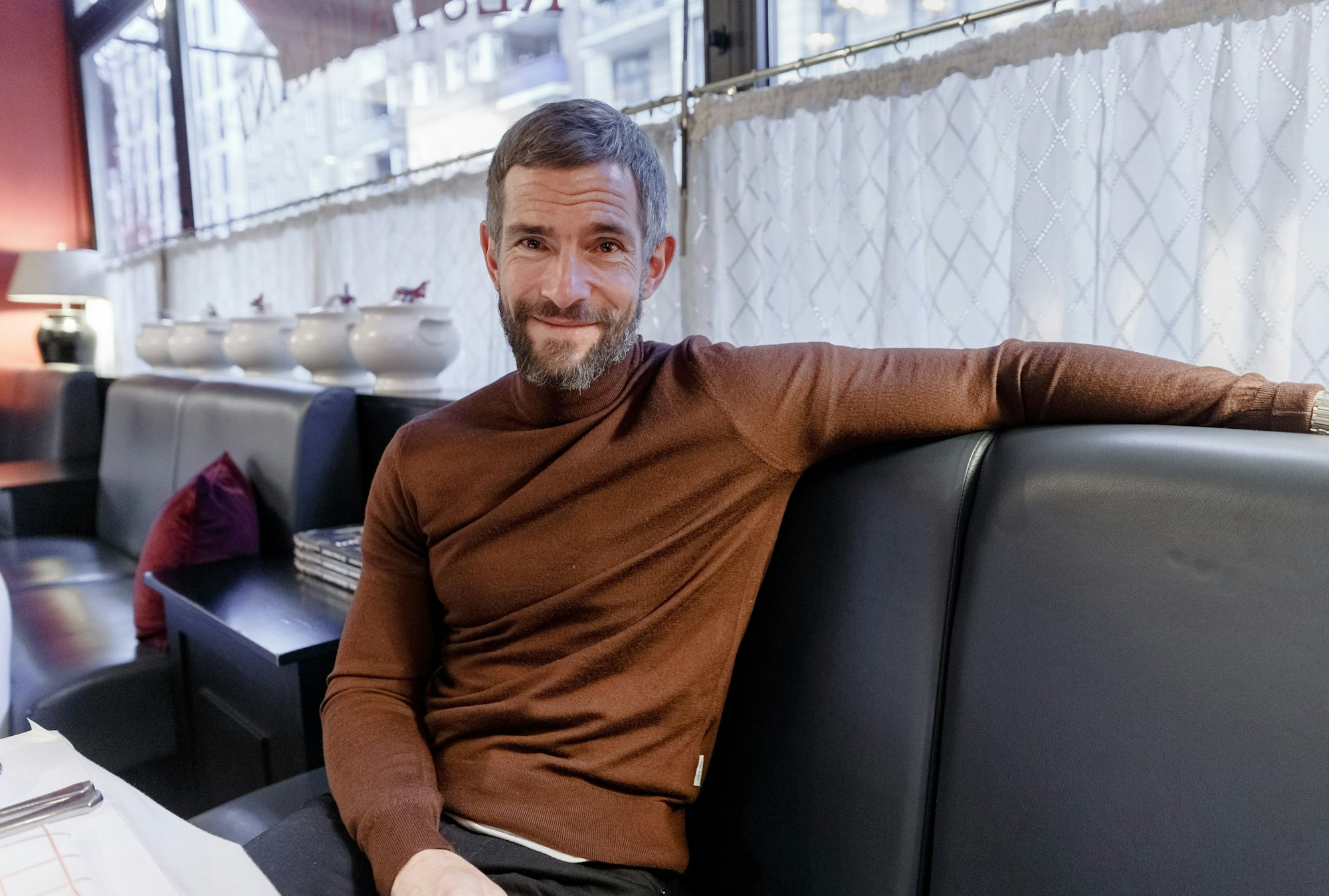 Der Journalist und Autor Micky Beisenherz sitzt an einem Tisch