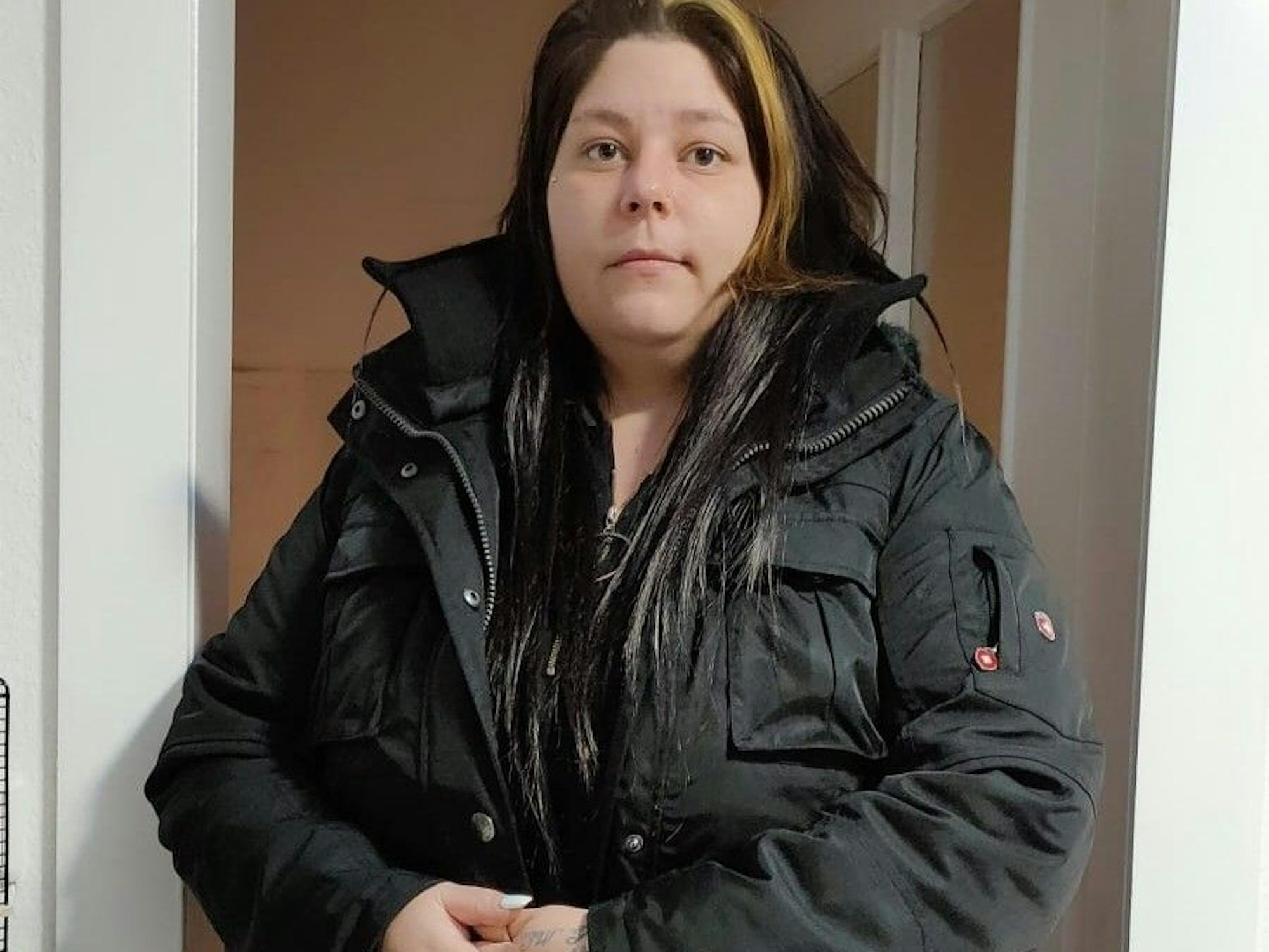 Joana N. aus Leverkusen schaut in die Kamera und steht in ihrer Wohnung.