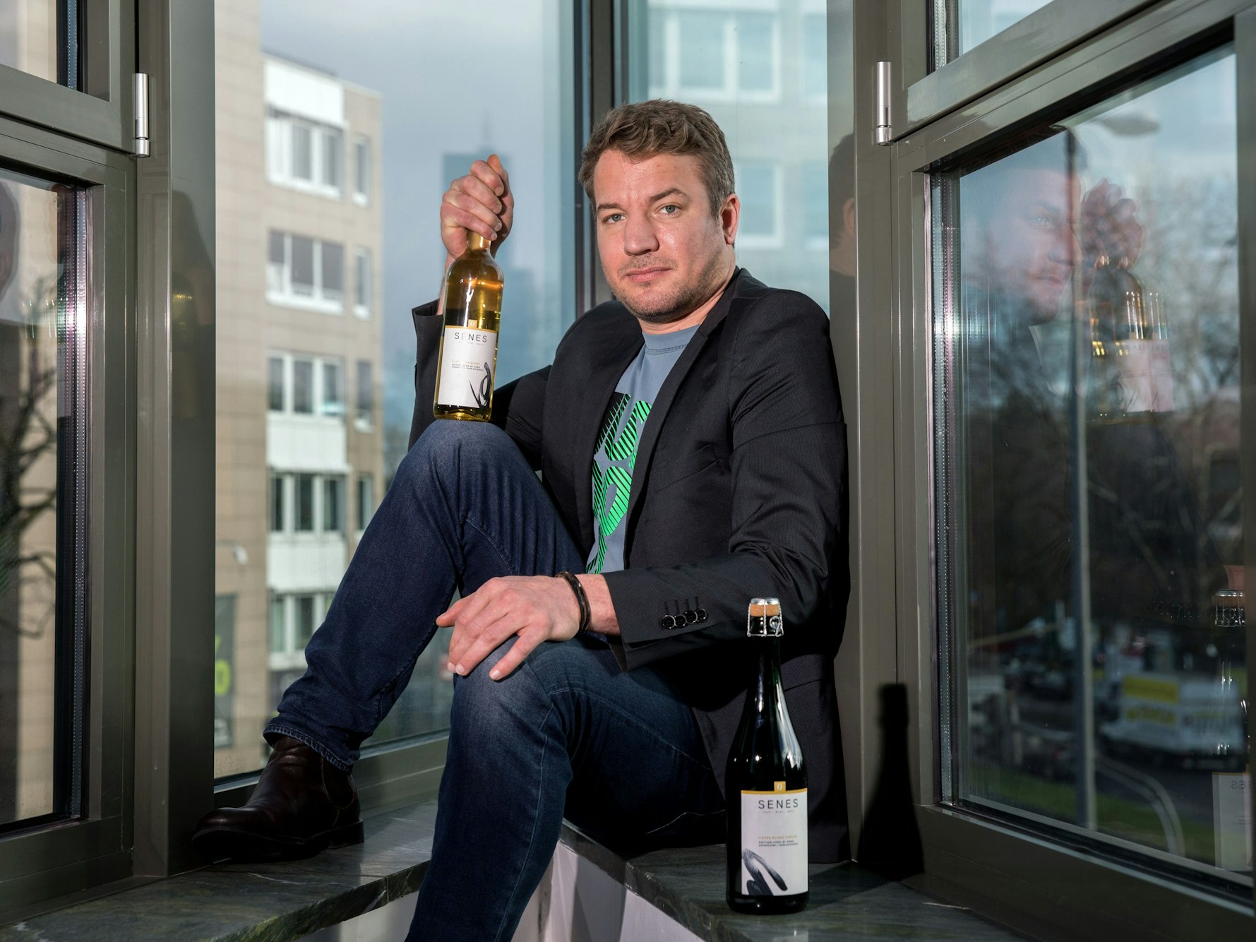 Der Kölner Gründer Christian Huettl mit zwei seiner Weine.