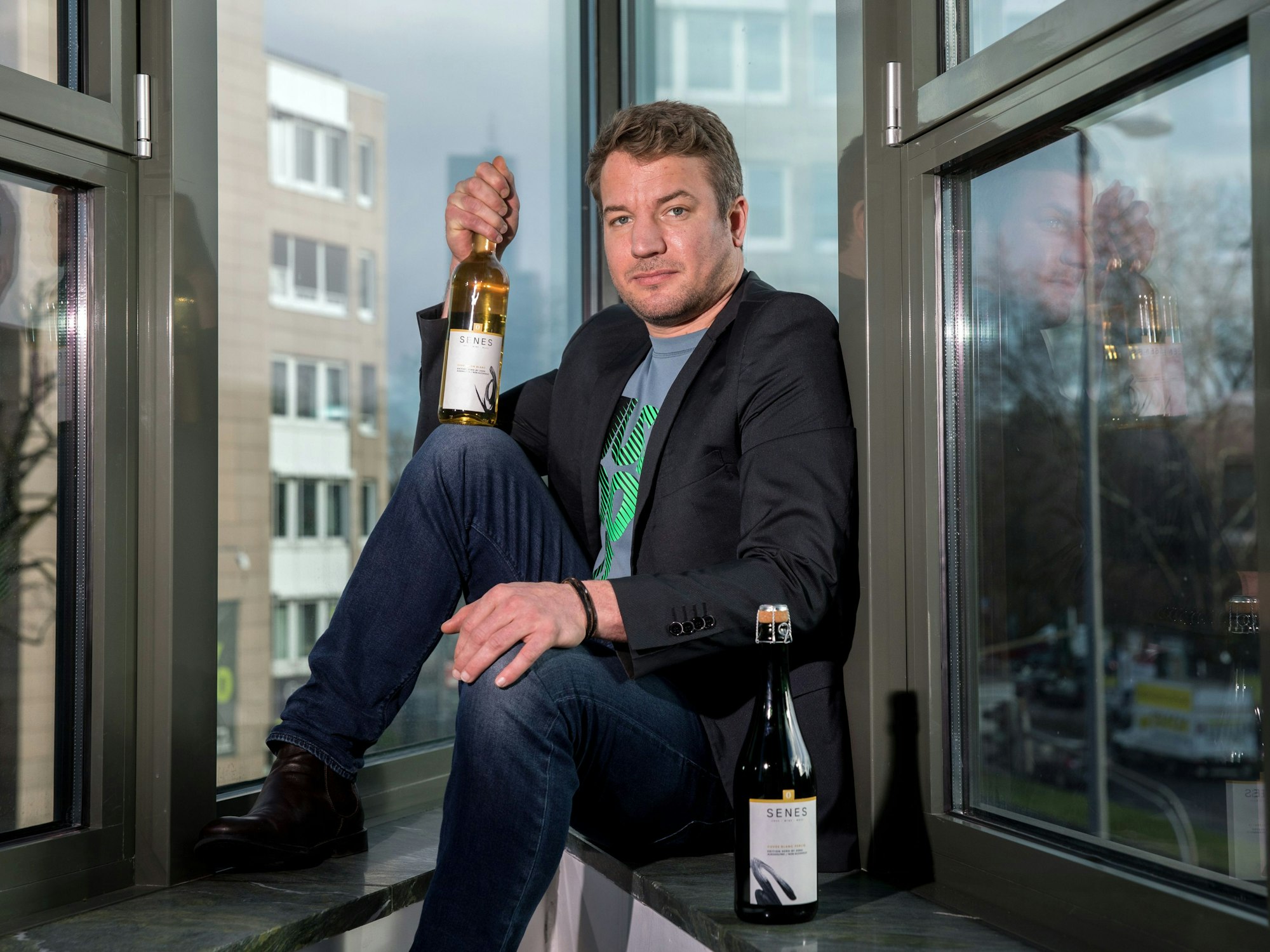 Der Kölner Gründer Christian Huettl mit zwei seiner Weine.