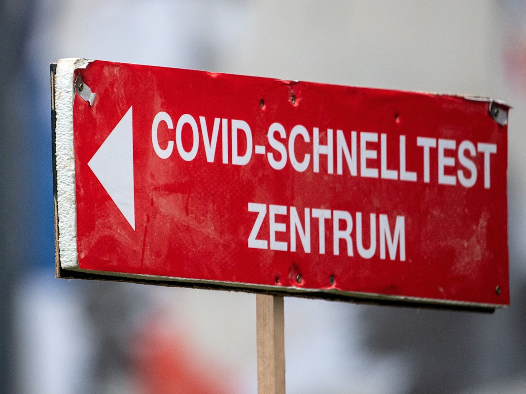 Ein Schild weist den Weg zu einem Corona-Schnelltestzentrum in Köln. Foto vom 27. Januar 2022.