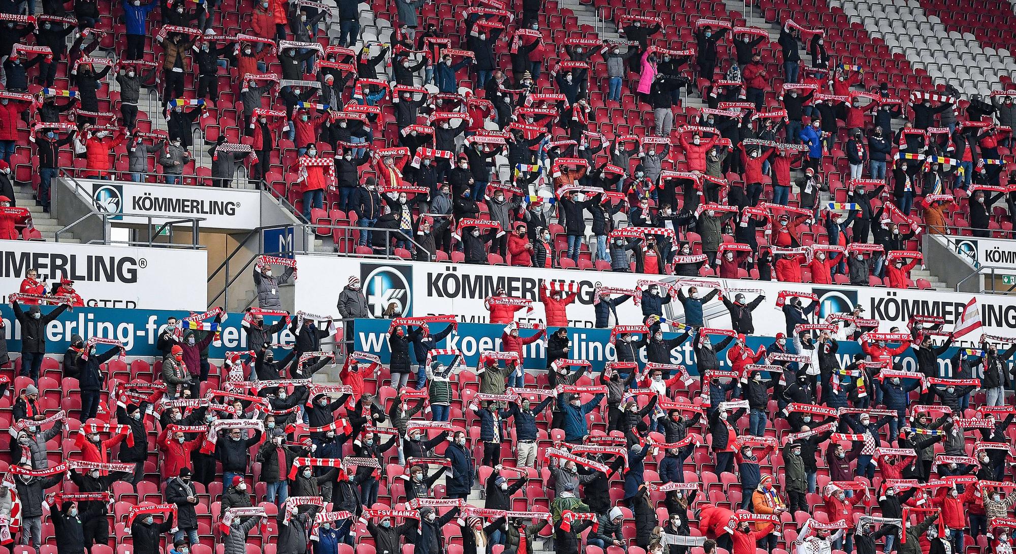 Fans des FSV Mainz 05 halten ihre Schals hoch.