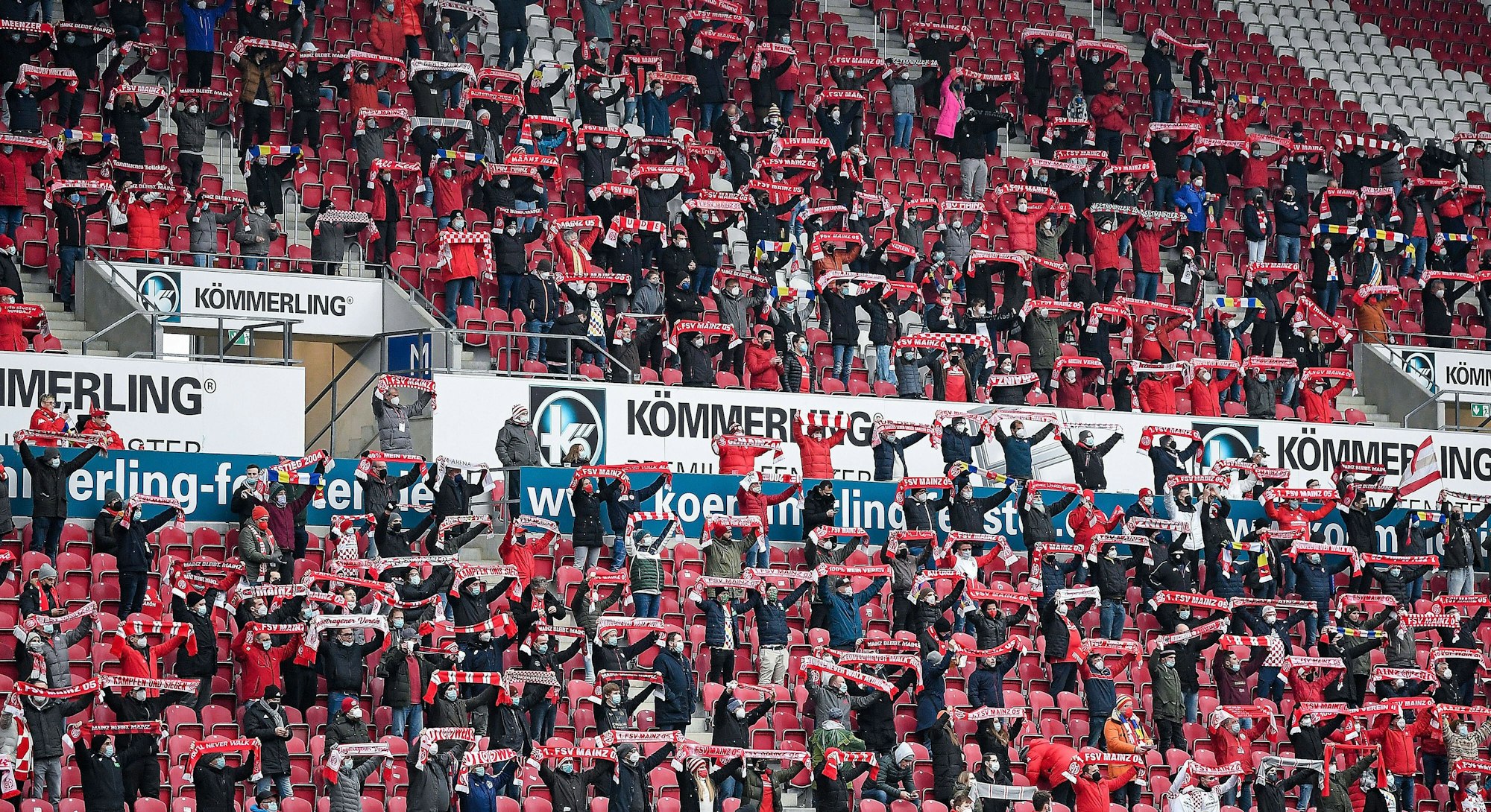 Fans des FSV Mainz 05 halten ihre Schals hoch.