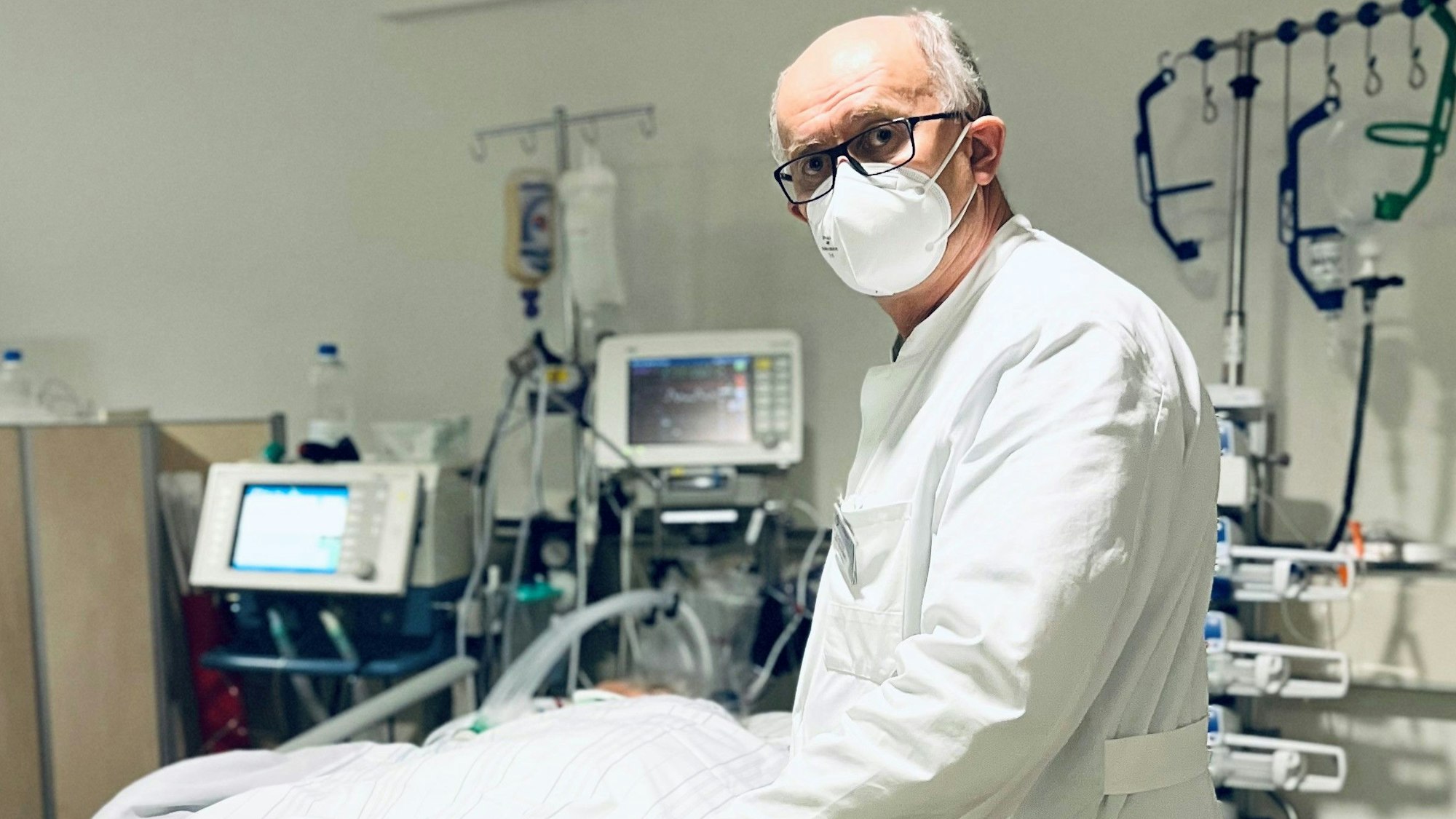 Dr. Gunther Quinkler steht am Krankenbett eines Patienten.