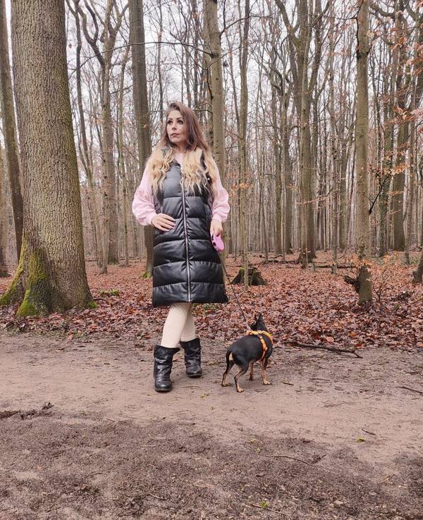 Joana N. aus Leverkusen geht im Wald mit ihrem Hund spazieren.