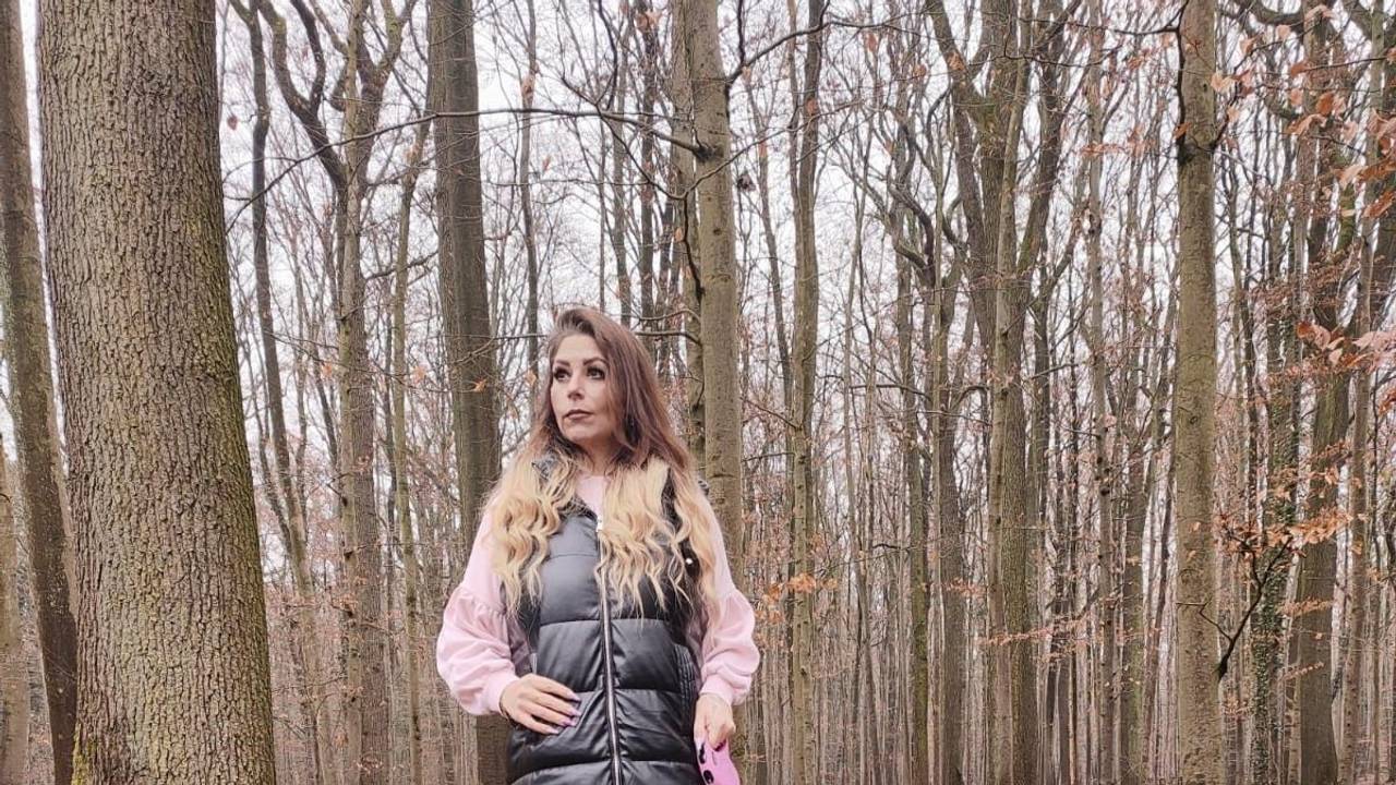 Joana N. aus Leverkusen geht im Wald mit ihrem Hund spazieren.
