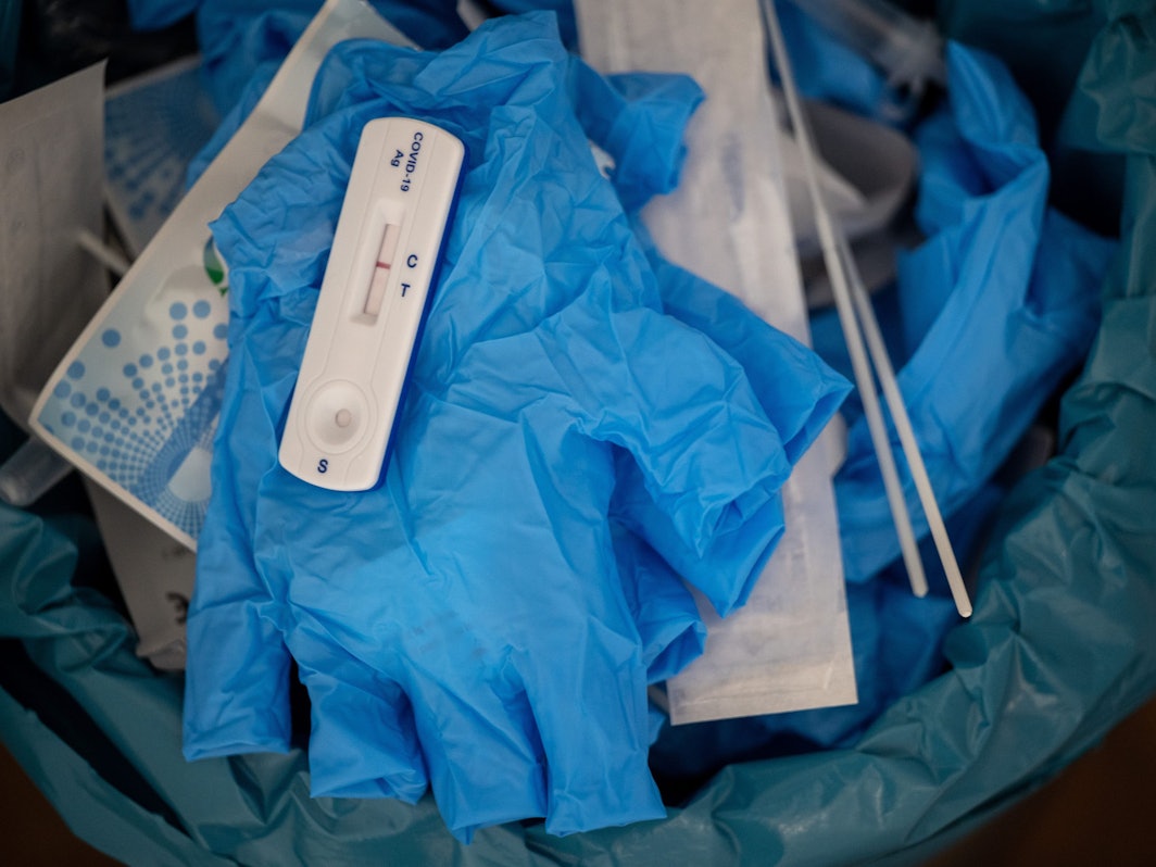 Ein negativer Covid-Schnelltest liegt auf diesem Symbolbild vom 27. Januar 2022 auf einem medizinischen Handschuh in einer Teststelle im Mülleimer. Nach falsch-positiven Ergebnissen hat die Firma Genrui Chargen ihrer Schnelltest zurückgerufen.