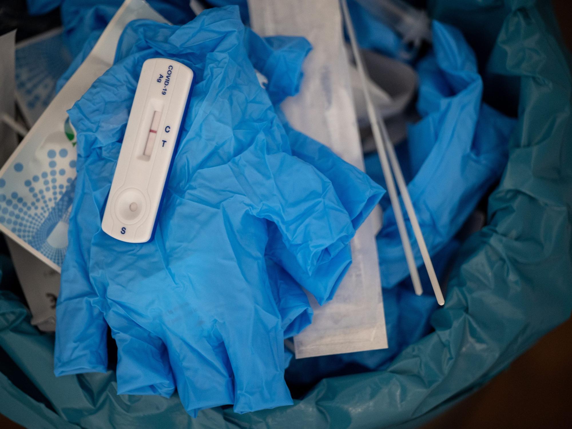 Ein negativer Covid-Schnelltest liegt auf diesem Symbolbild vom 27. Januar 2022 auf einem medizinischen Handschuh in einer Teststelle im Mülleimer. Nach falsch-positiven Ergebnissen hat die Firma Genrui Chargen ihrer Schnelltest zurückgerufen.