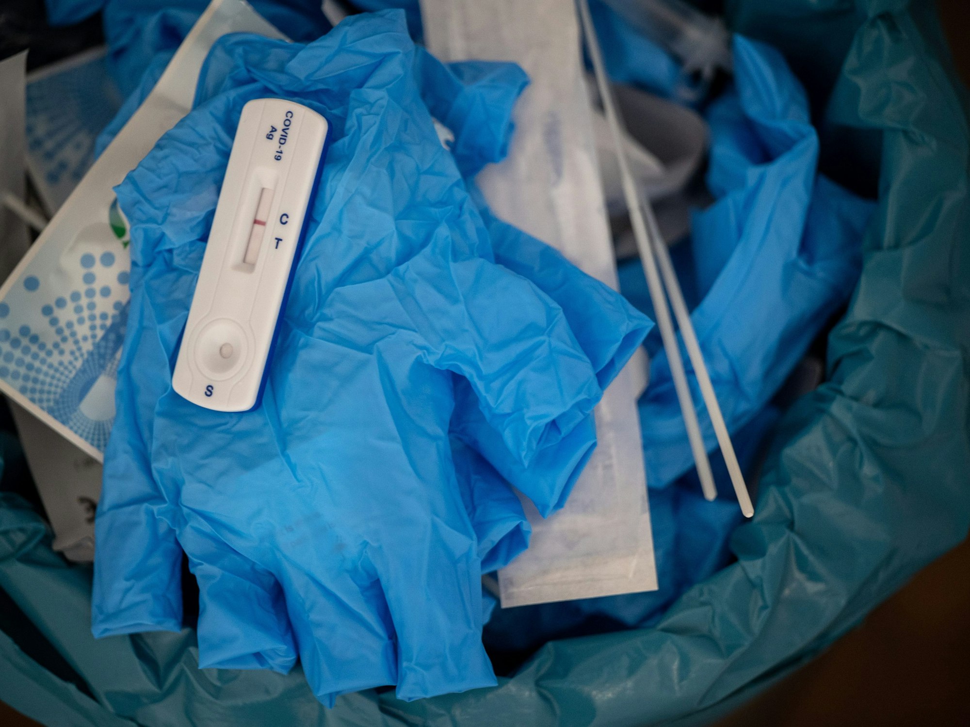 Ein negativer Covid-Schnelltest liegt auf diesem Symbolbild vom 27. Januar 2022 auf einem medizinischen Handschuh in einer Teststelle im Mülleimer. Nach falsch-positiven Ergebnissen hat die Firma Genrui Chargen ihrer Schnelltest zurückgerufen.