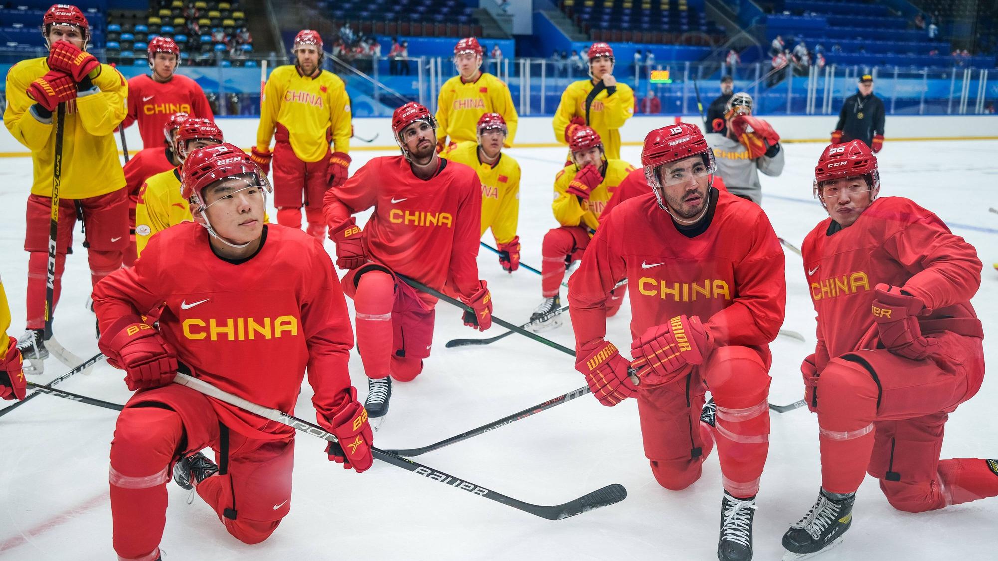 Die Spieler der Nationalmannschaft Chinas knien auf dem Eis.