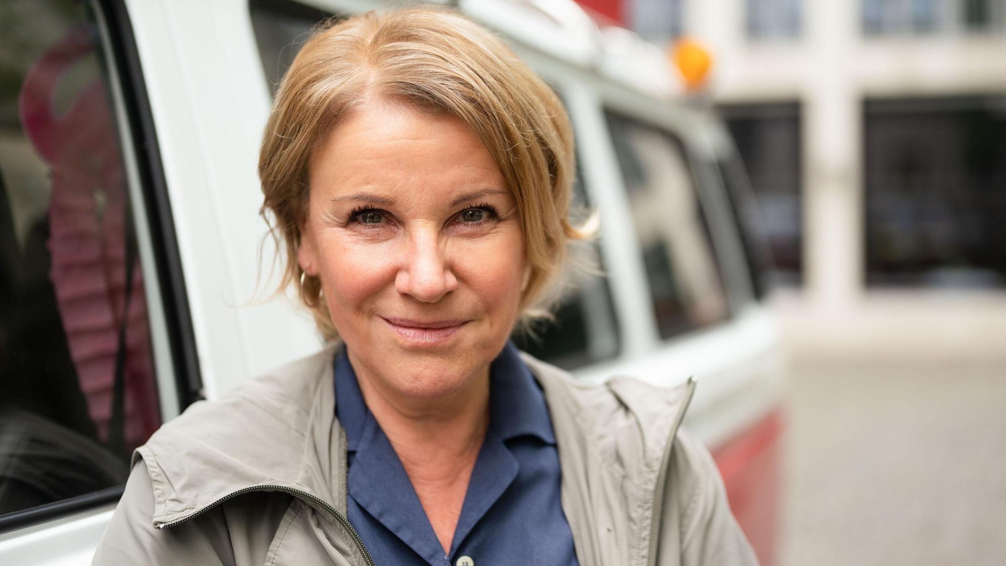 Die Schauspielerin Mariele Millowitsch steht neben einem Bulli von «Liebe deine Stadt - Touren», den sie zuvor auf ihren Namen getauft hat.
