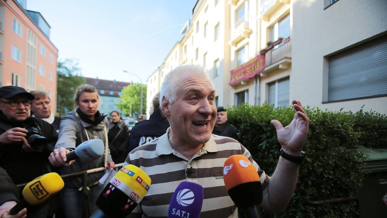 Ein Mann steht vor mehreren Mikrofonen.