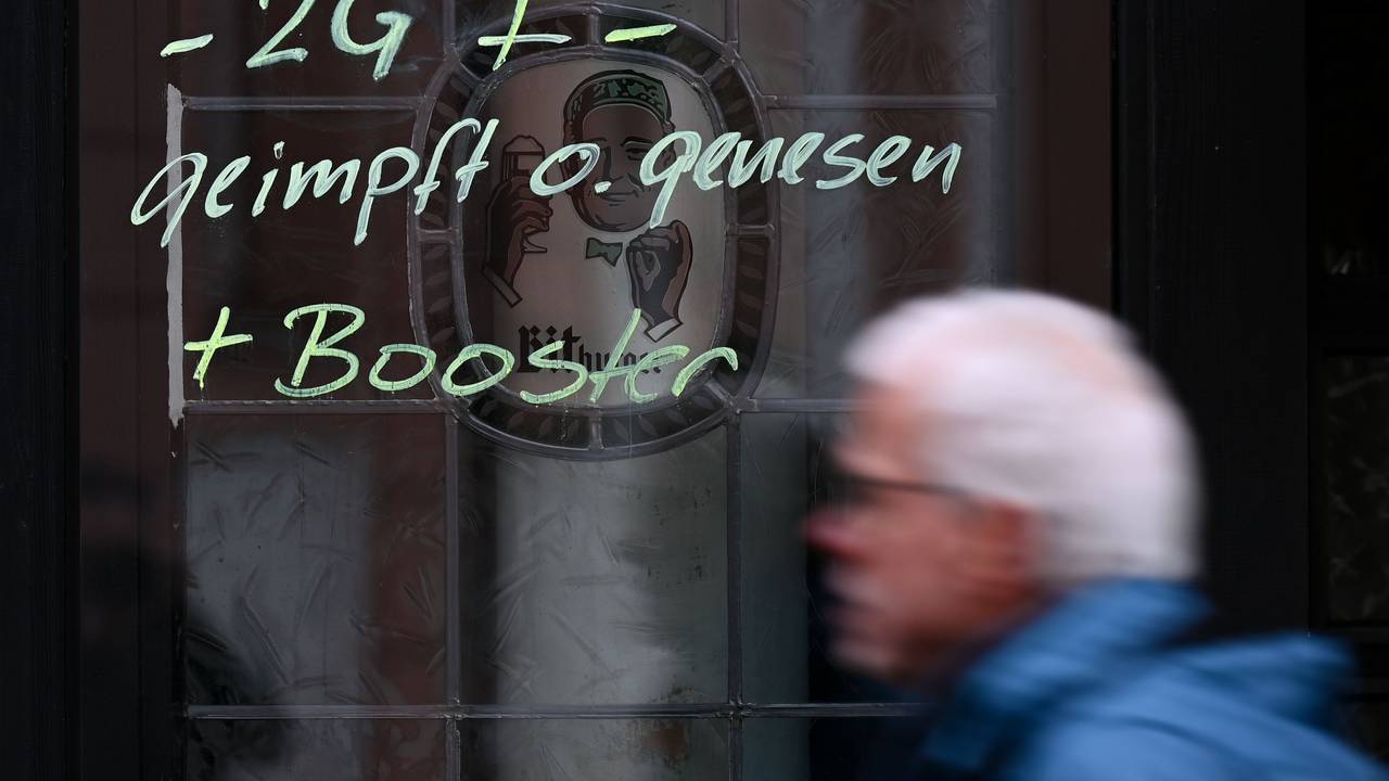 Am Fenster eines Lokals ist der Hinweis „-2G + - geimpft o. genesen + Booster“ aufgemalt.