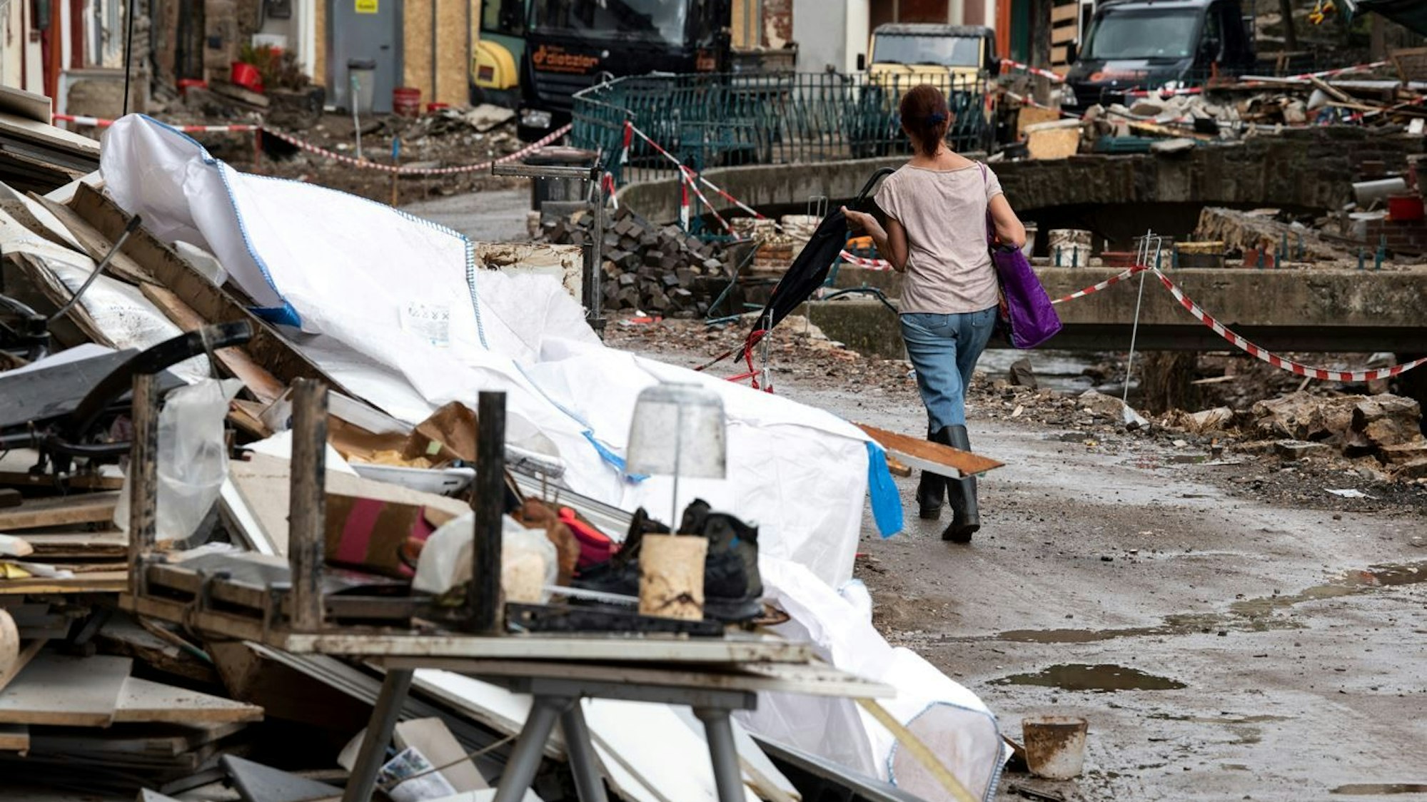 Nordrhein-Westfalen, Bad Münstereifel: Eine Frau geht durch die von der Flut zerstörte Innenstadt.
