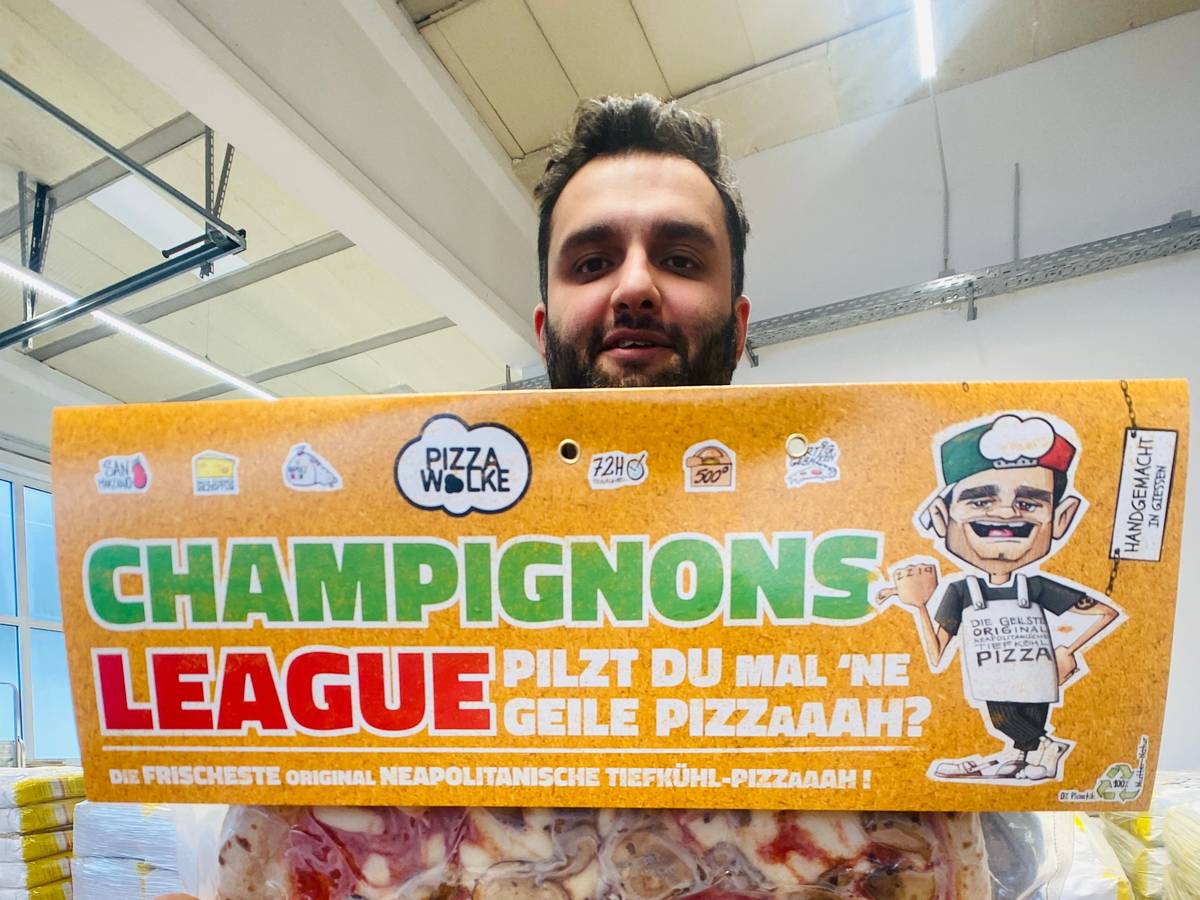 Shadi Souri hält eine Pizza in die Kamera.