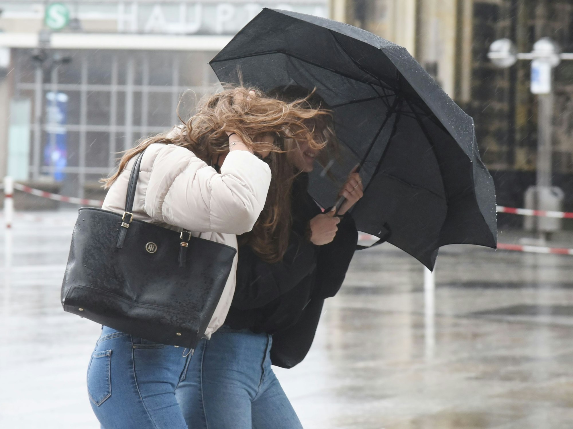 Passanten rund um den Dom kämpfen gegen Wind und Regen.