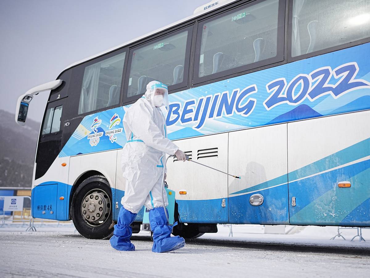 Zhangjiakou bei Peking: Ein Arbeiter besprüht einen Olympia-Bus.