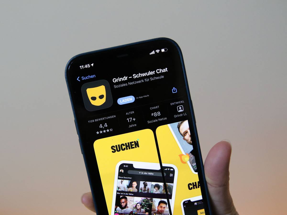 Eine Frau zeigt die Grindr-App im App Store von Apple auf einem iPhone 12 Pro Max.
