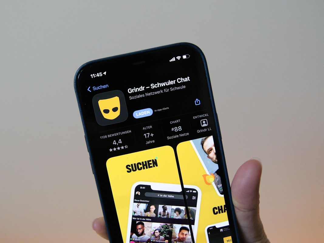 Eine Frau zeigt die Grindr-App im App Store von Apple auf einem iPhone 12 Pro Max.