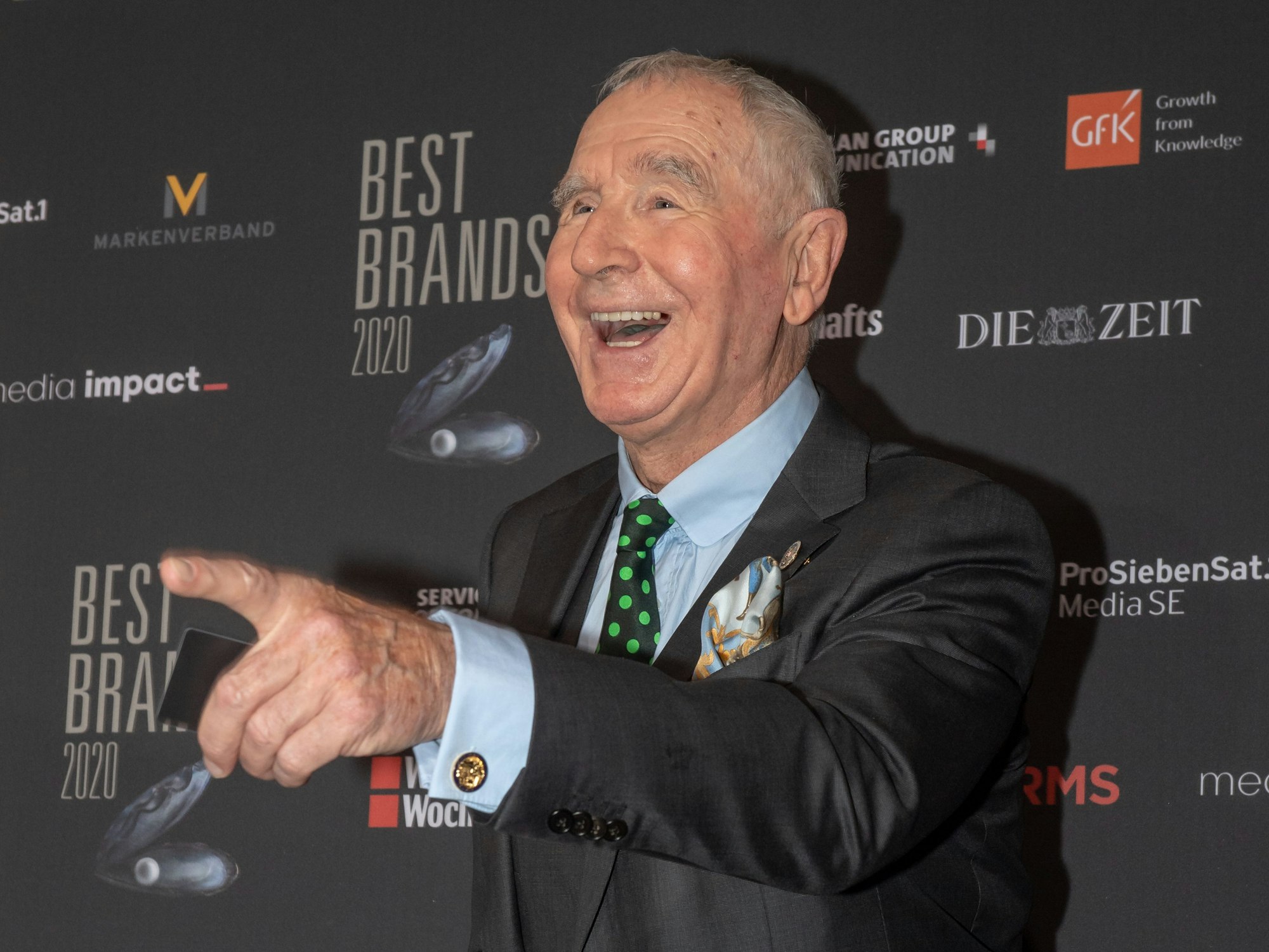 Der lachende Prinz Frédéric von Anhalt steht auf dem roten Teppich und zeigt mit dem Zeigefinger nach vorne.