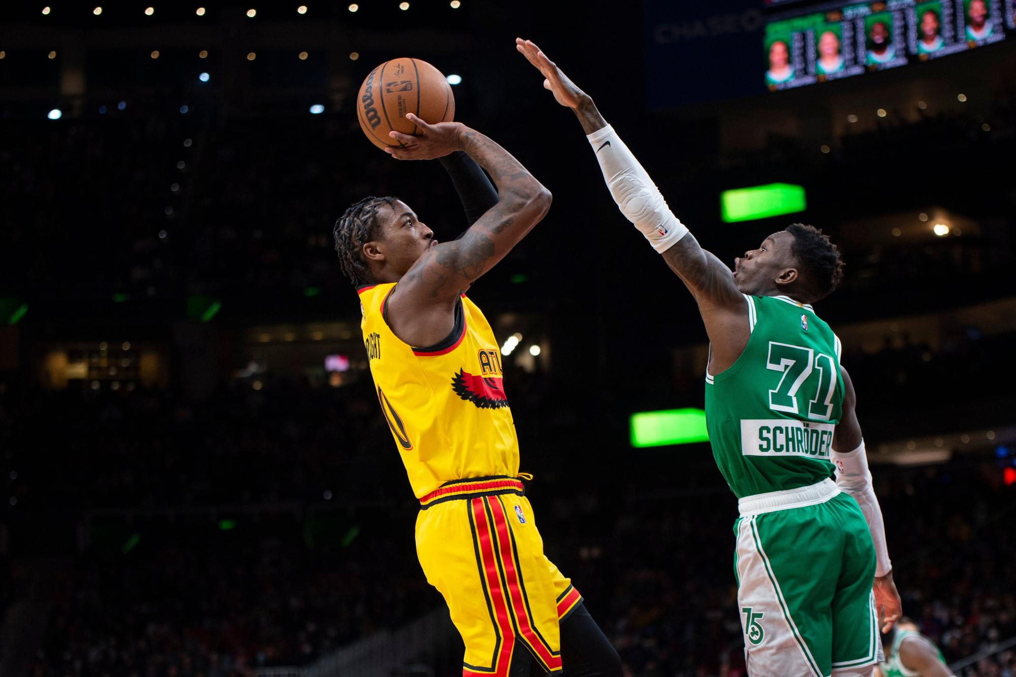 Atlanta Hawks Delon Wright wirft über Boston Celtics Guard Dennis Schroder hinweg.