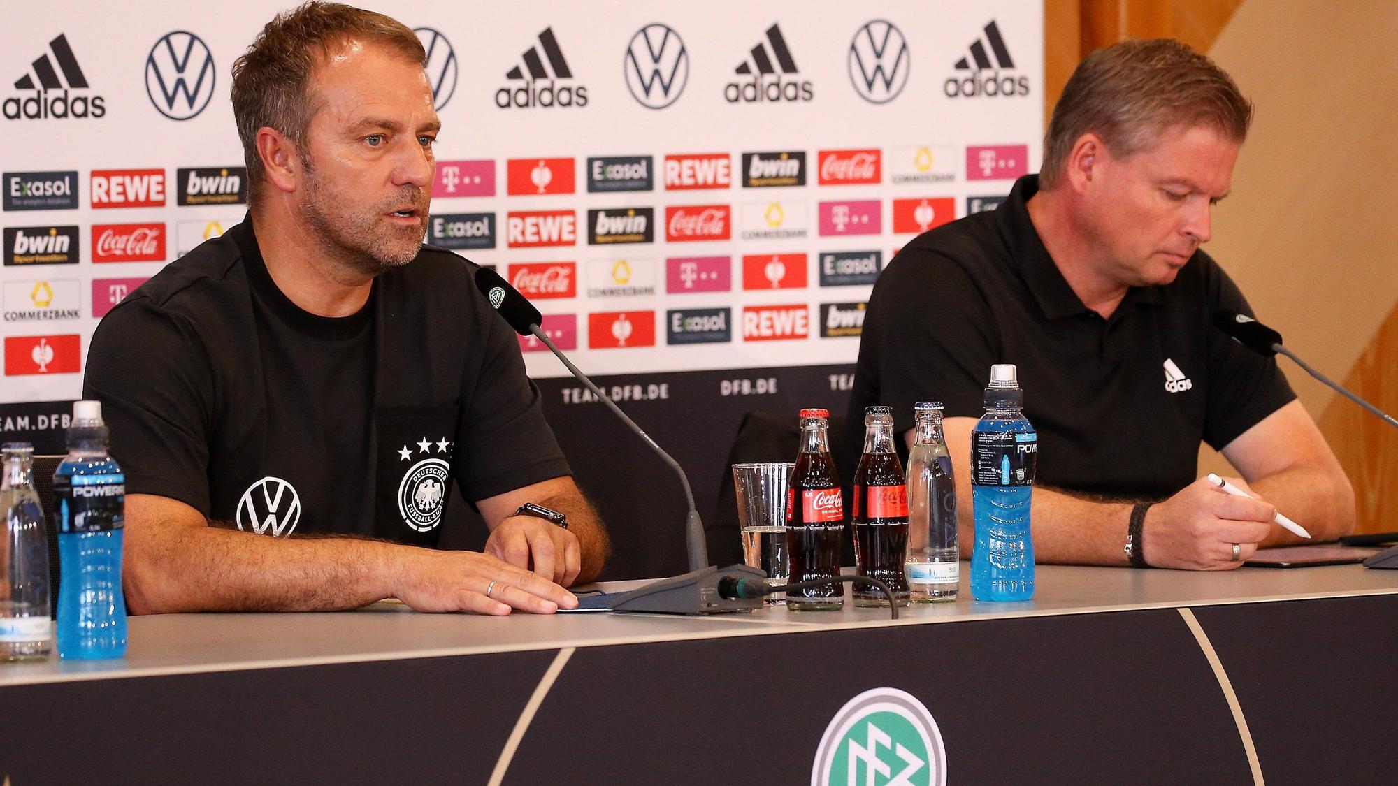 Jens Grittner macht sich während einer Pressekonferenz von Hansi Flick Notizen