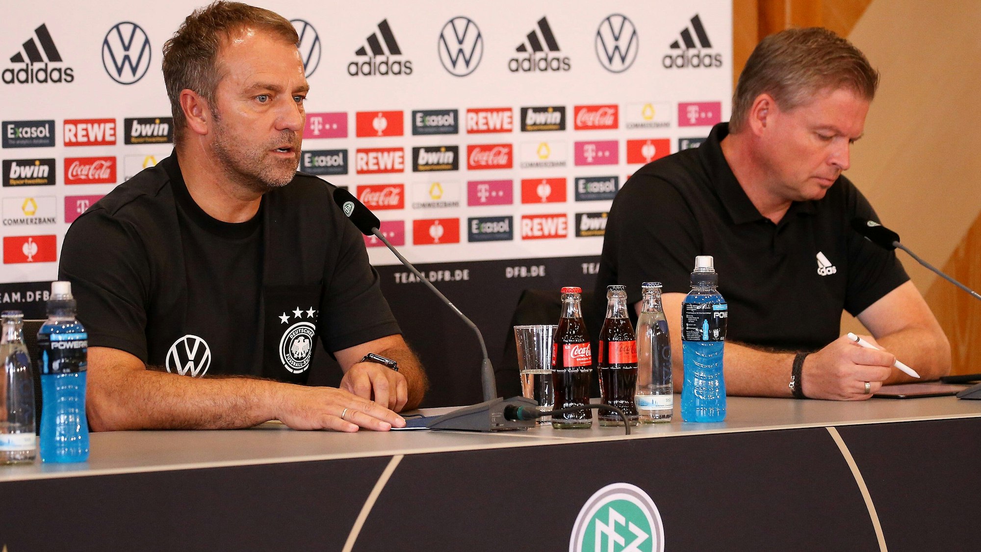 Jens Grittner macht sich während einer Pressekonferenz von Hansi Flick Notizen