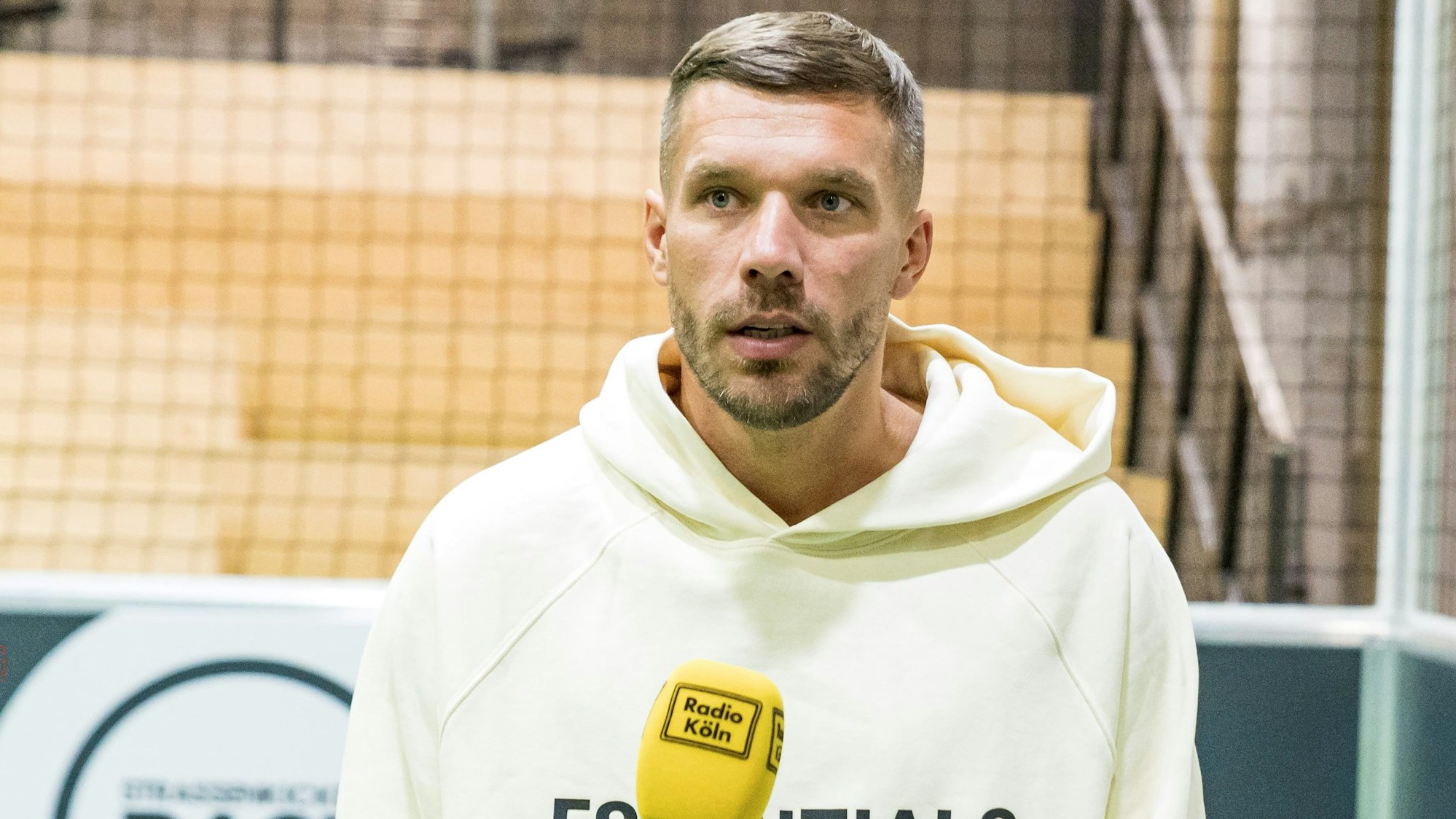 Lukas Podolski gibt ein Interview in Köln