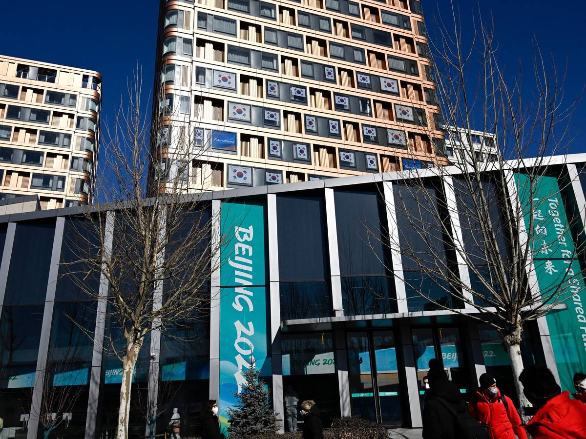 Menschen spazieren im Olympischen Dorf. Die Olympischen Winterspiele in Peking finden vom 4. bis 20. Februar 2022 unter strengen Corona-Auflagen statt.